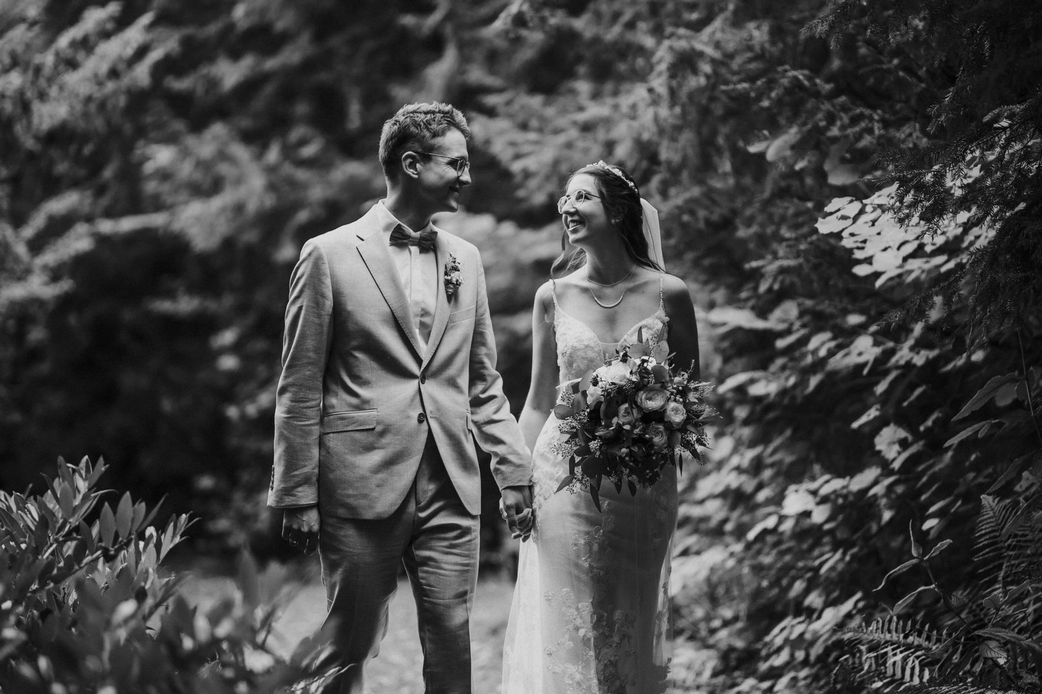 Verträumte Brautpaarfotos im Garten des Hotel Freigeist – Das frisch vermählte Paar genießt intime Momente der Zweisamkeit inmitten der grünen Oase, ein wundervolles Spiel aus Liebe und Natur.