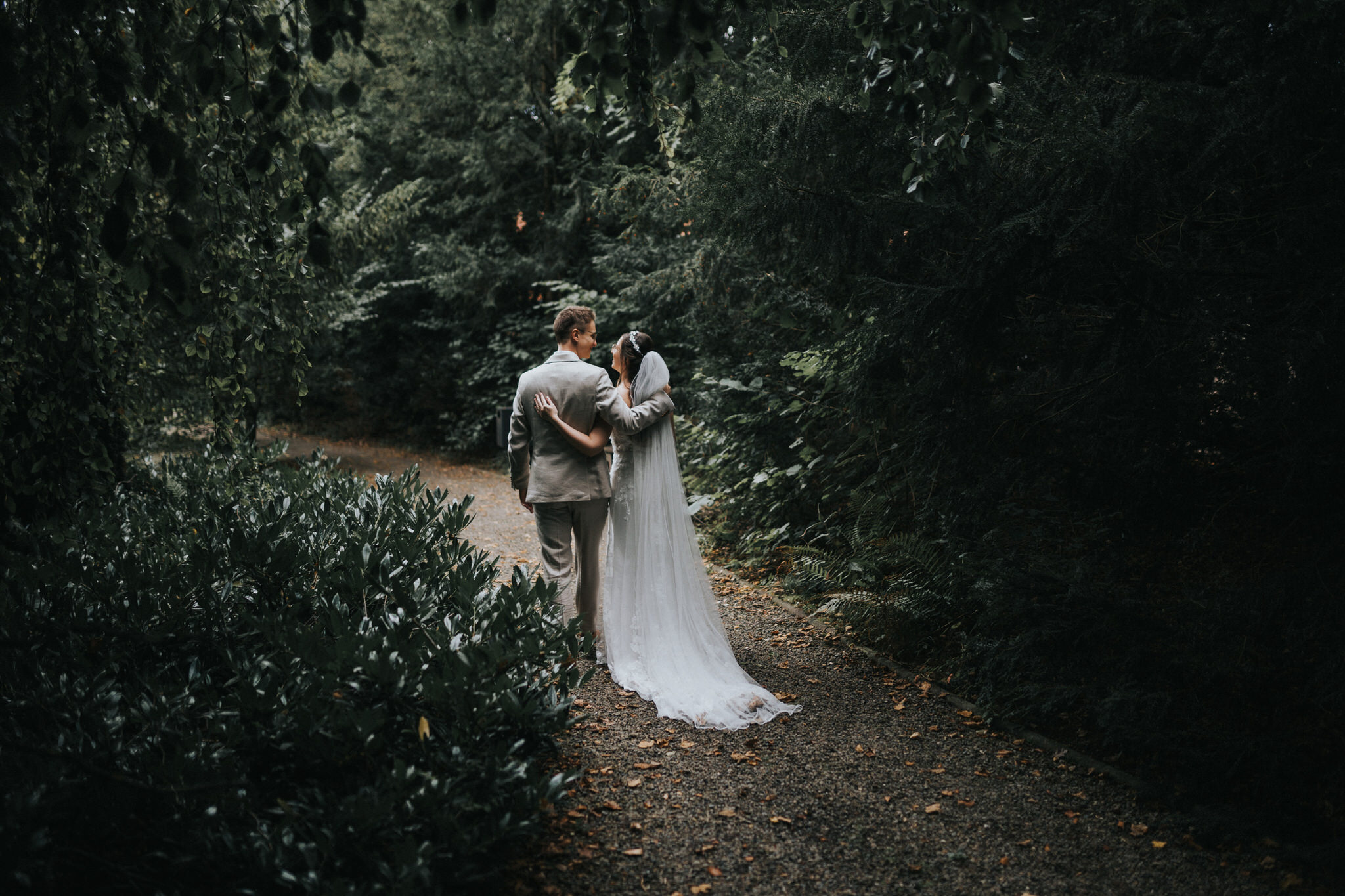 Verträumte Brautpaarfotos im Garten des Hotel Freigeist – Das frisch vermählte Paar genießt intime Momente der Zweisamkeit inmitten der grünen Oase, ein wundervolles Spiel aus Liebe und Natur.