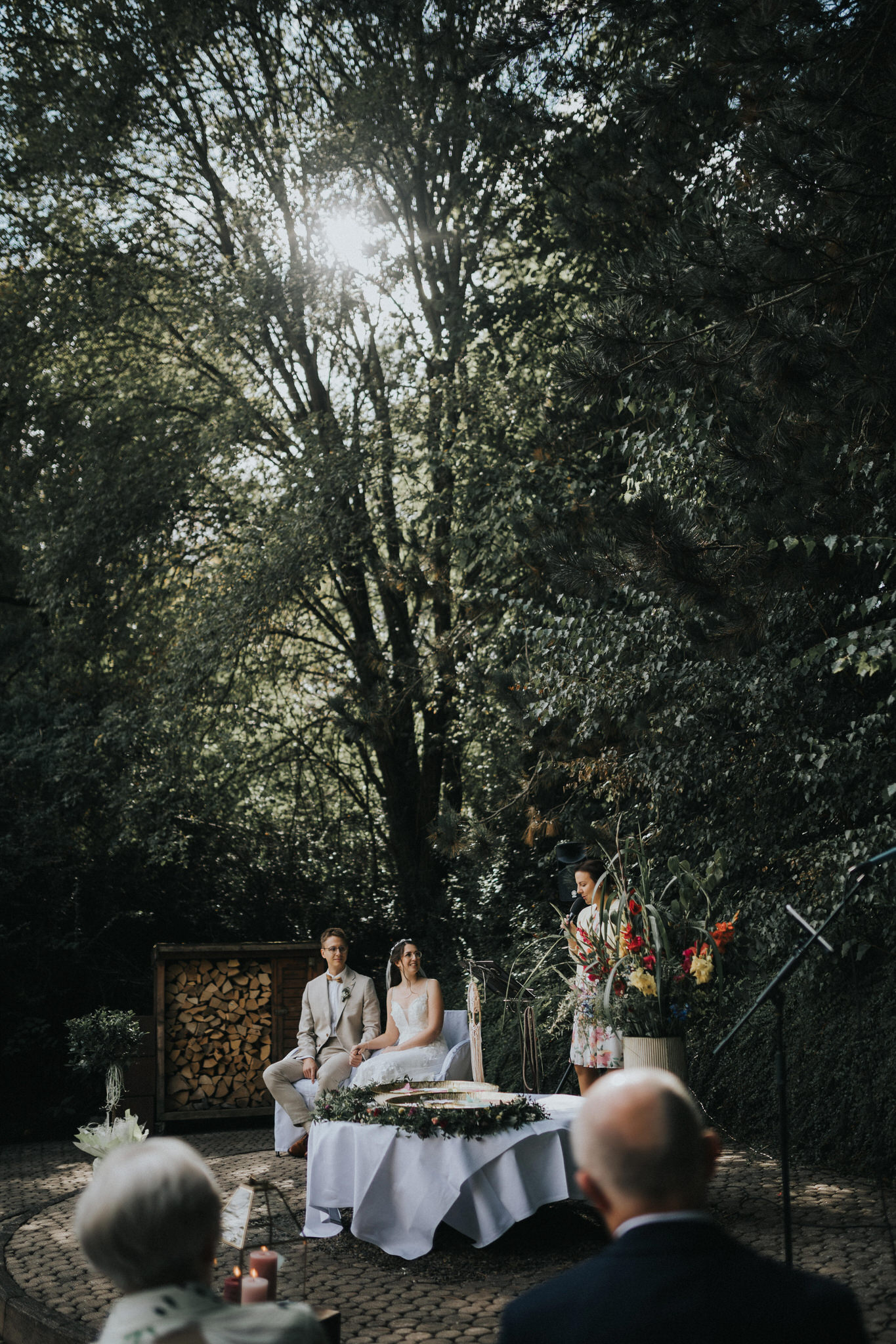 Berührende freie Trauung im Garten des Hotel Freigeist – Das Brautpaar gibt sich unter blauem Himmel das Ja-Wort, umgeben von Familie und Freunden in einer malerischen Gartenkulisse.