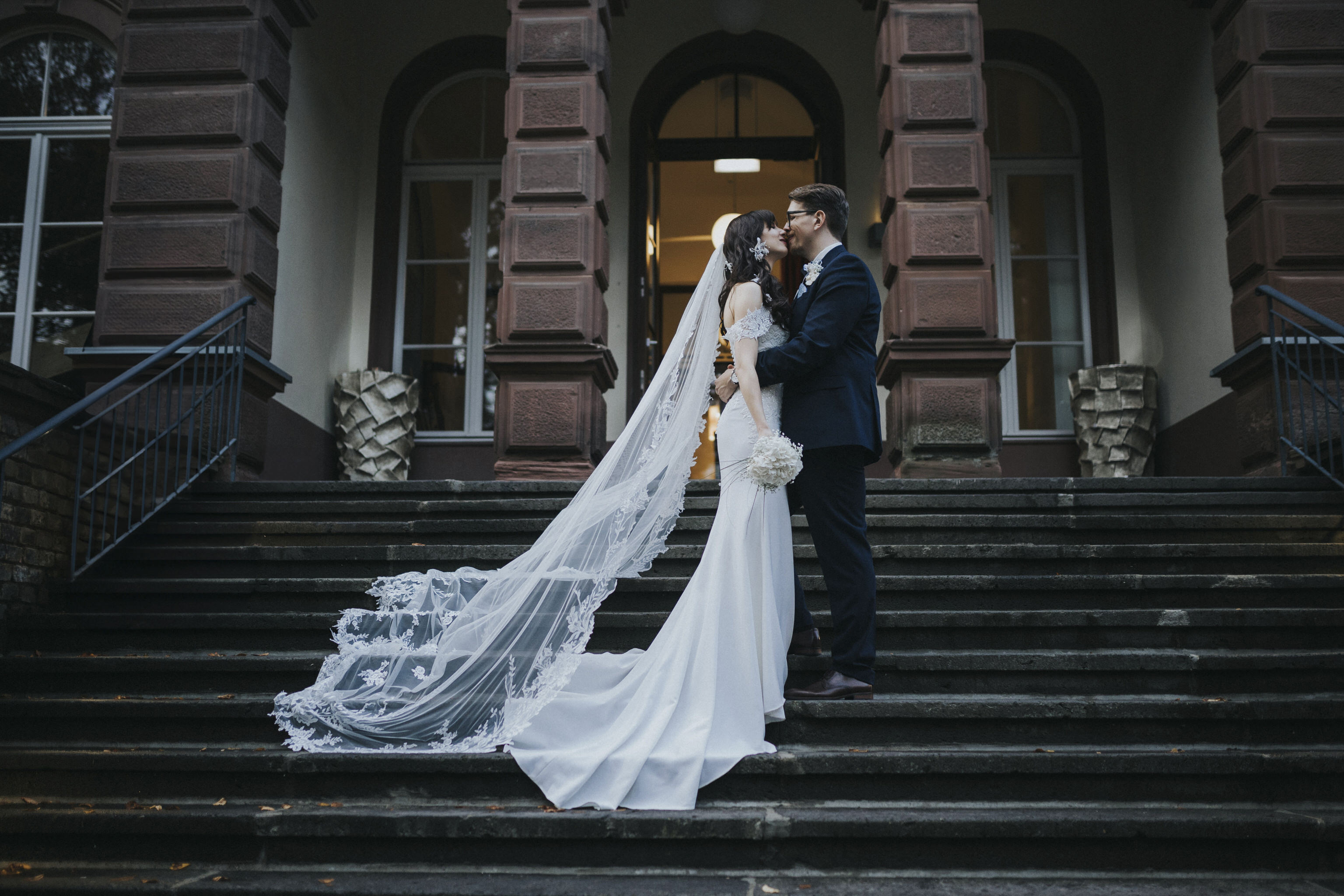 Verliebtes Brautpaar vor den historischen Elementen des Kaiserbahnhofs – romantische Brautpaarfotos, die die Liebe inmitten des charmanten Ambientes einfangen.