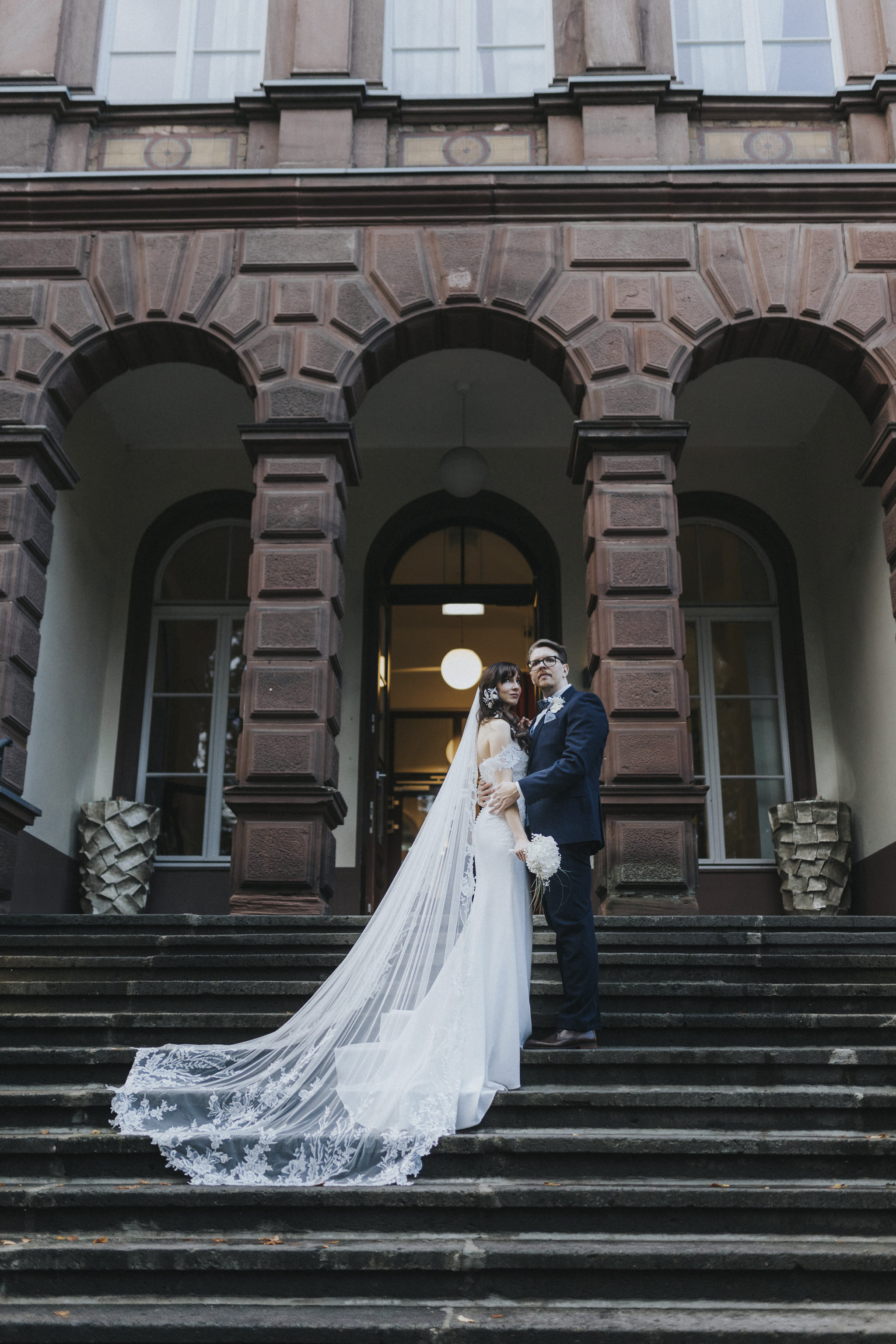 Verliebtes Brautpaar vor den historischen Elementen des Kaiserbahnhofs – romantische Brautpaarfotos, die die Liebe inmitten des charmanten Ambientes einfangen.
