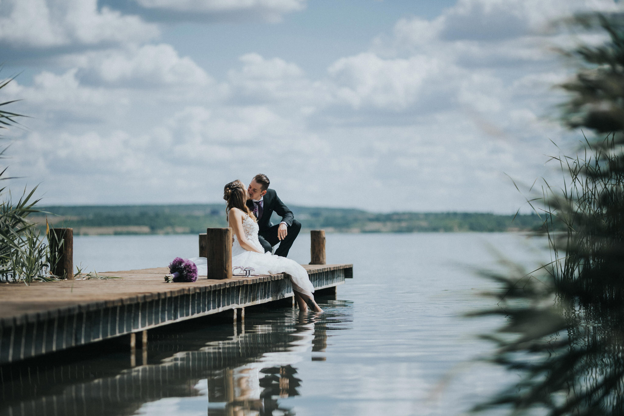 Idyllisches Brautpaarfotoshooting am Seeufer – Die Liebe des Paares wird in romantischen Bildern eingefangen, während sie entlang des Ufers spazieren und den Zauber des Augenblicks erleben.