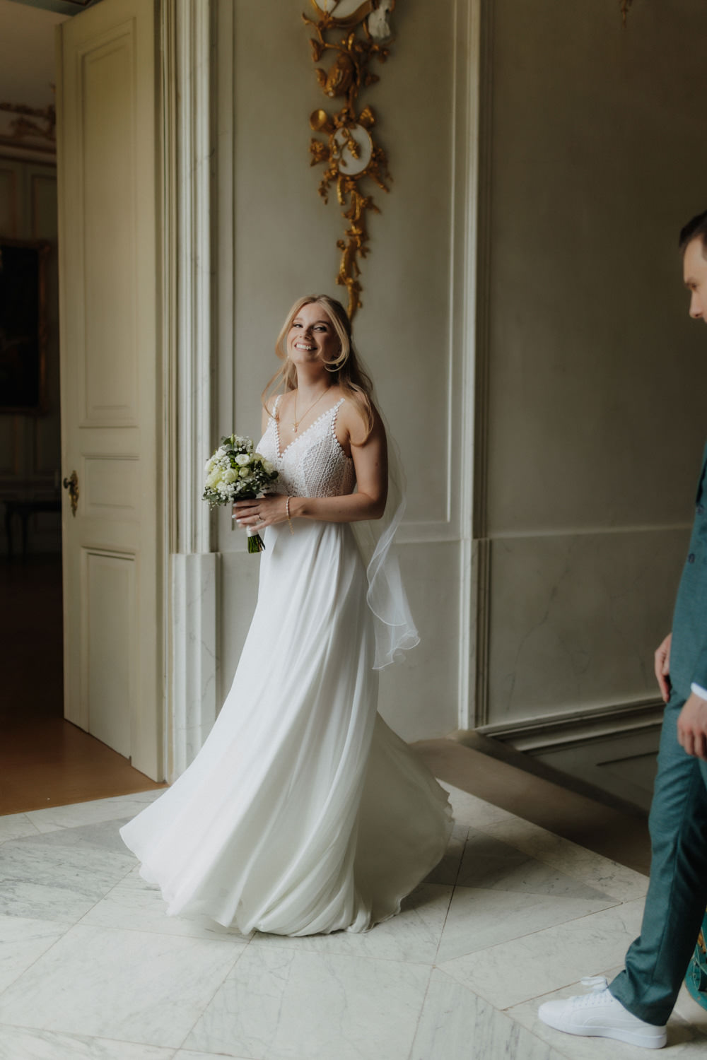 Braut-dreht-sich-im-Schloss Lächelnde Braut mit Strauß im Schloss Wilhelmsthal, Hochzeitsfotograf Kassel