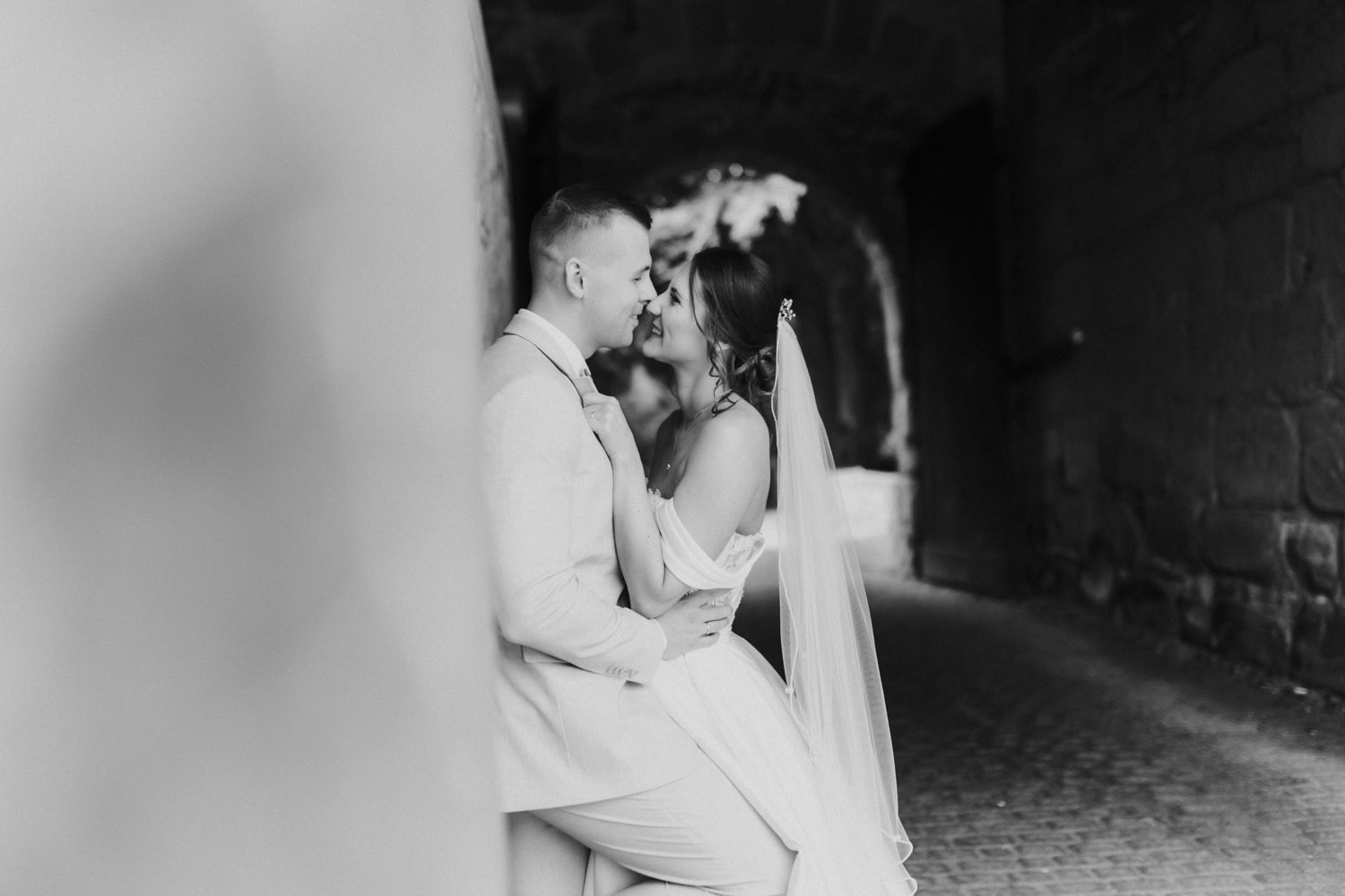 Paar sitzt verliebt im Torbogen, Burg Hardegsen Hochzeit