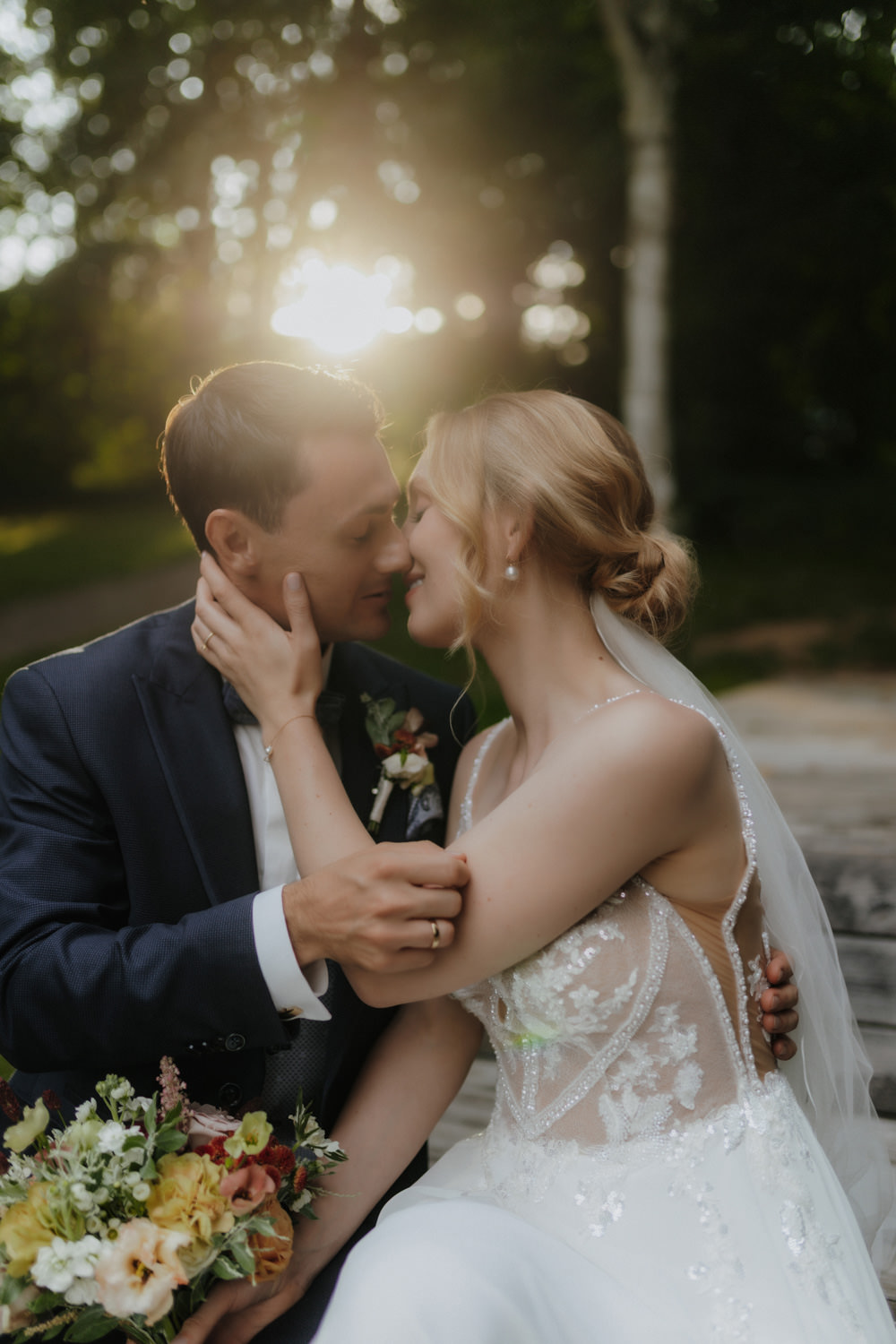 Brautpaar küsst sich im Gegenlicht bei goldenem Abendlicht