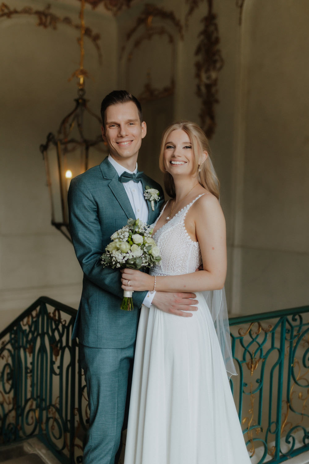 Brautpaar-beim-Fotoshooting-im-Schloss-Wilhelmsthal Hochzeitspaar umarmt sich lachend im barocken Treppenhaus in Kassel