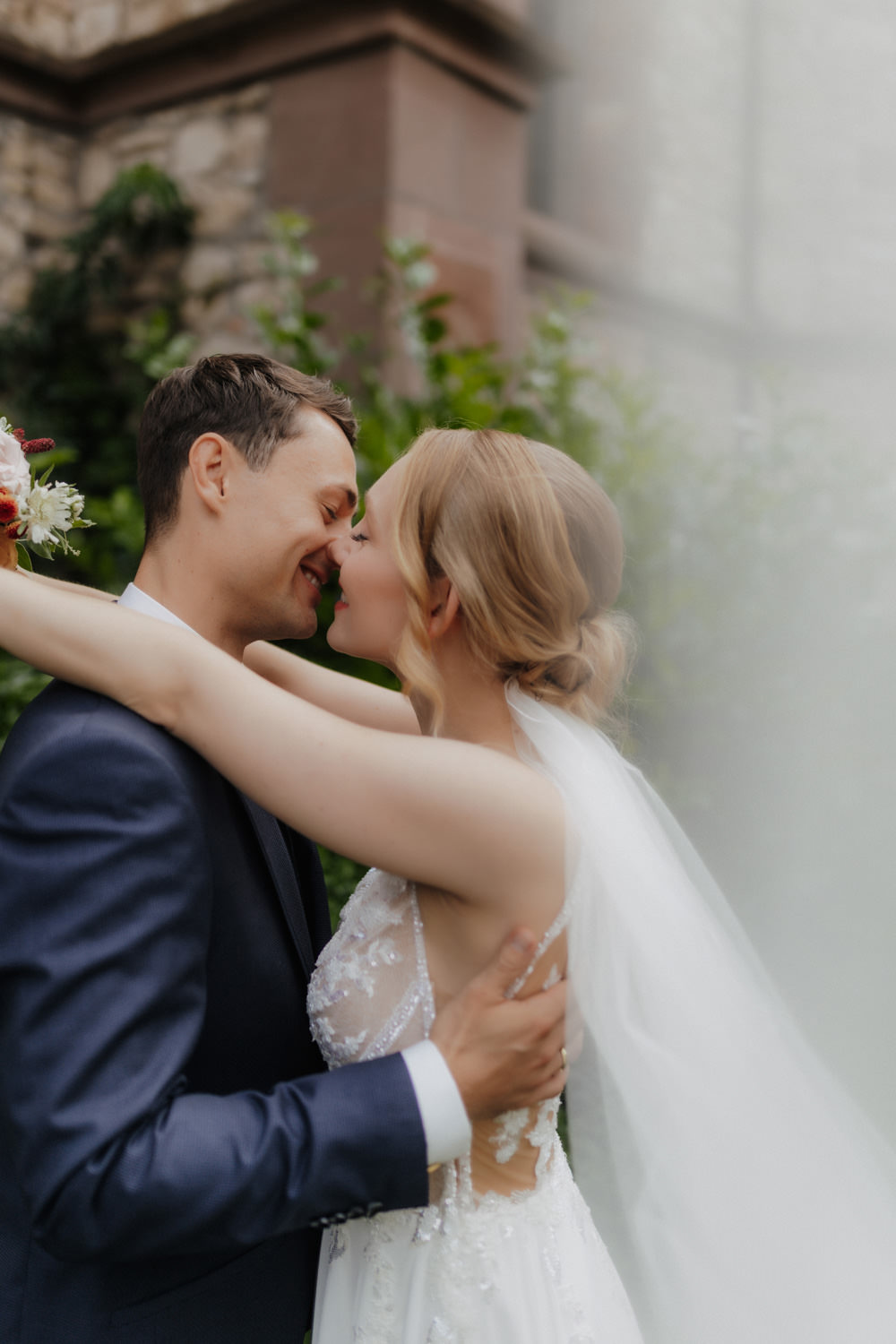 Kussmoment vor historischem Gebäude in Göttingen – Braut und Bräutigam innig vereint