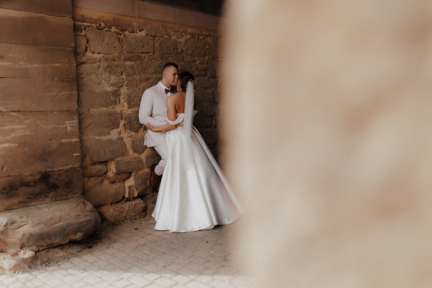 Hochzeitspaar vor Natursteinwand, Hochzeitsfotograf Göttingen Moment
