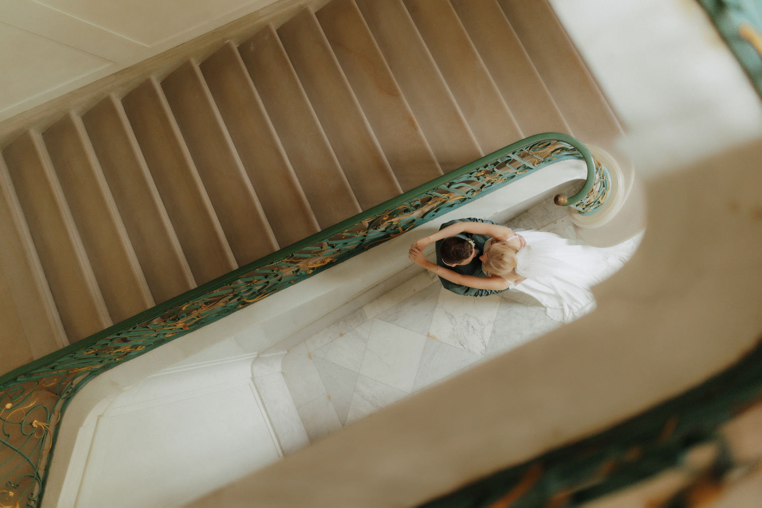 Brautpaar-im-Treppenhaus-im-Schloss Vogelperspektive: Brautpaar umarmt sich auf kunstvoller Treppe in Kassel