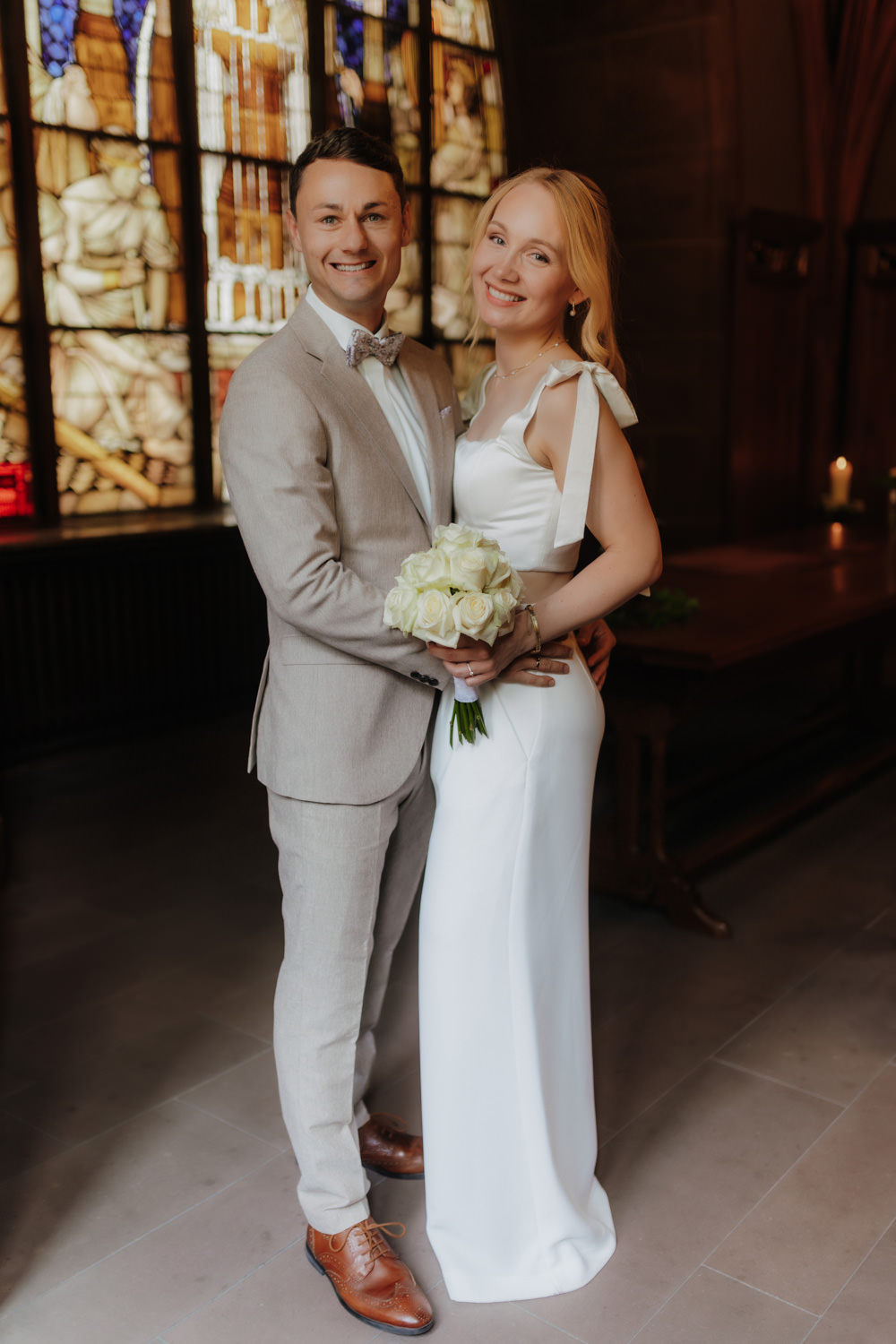 Porträt vom Brautpaar vor farbigem Fenster im alten Rathaus Göttingen