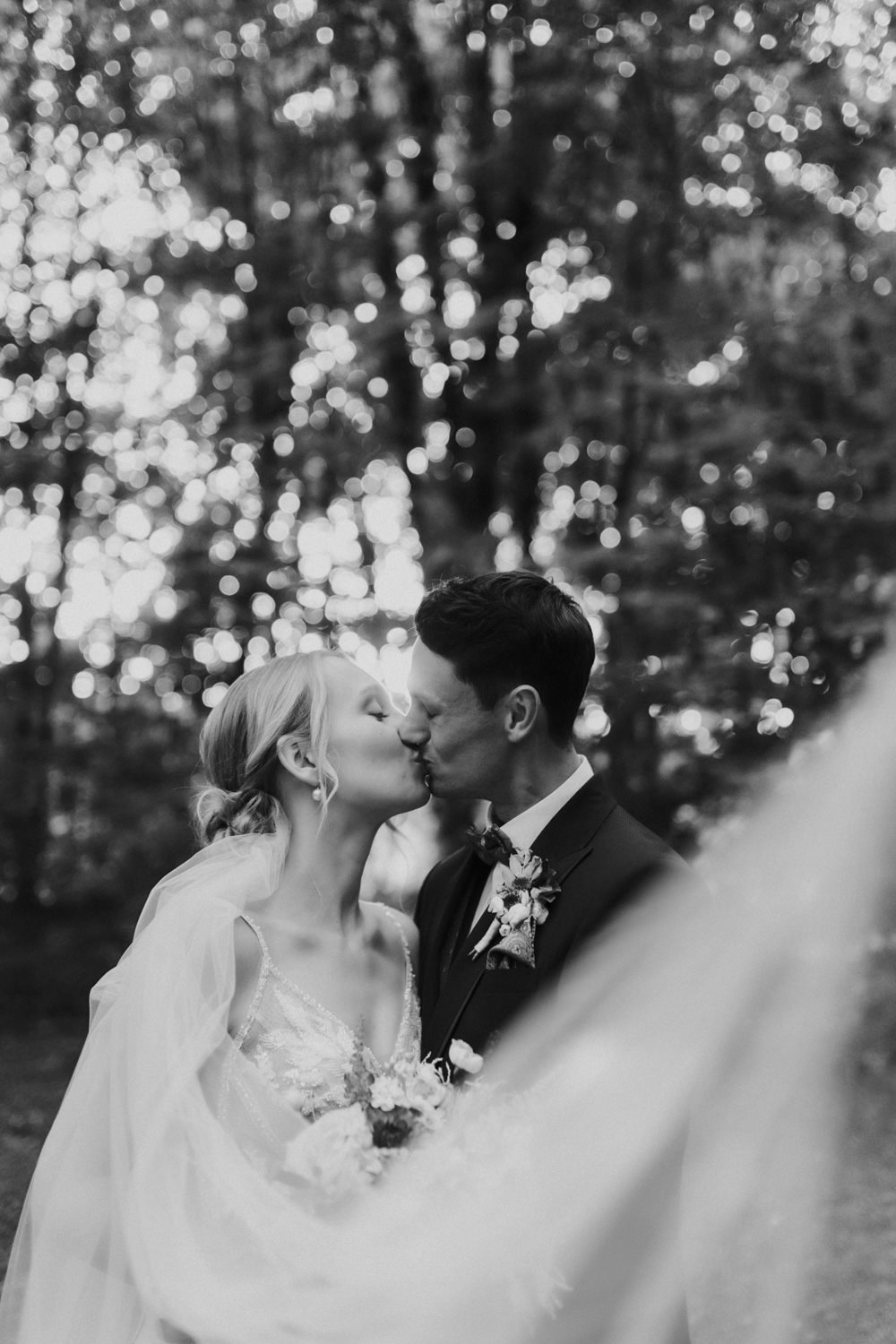 Kussmoment im Wald mit Lichtspiel – romantische Hochzeitsreportage Göttingen