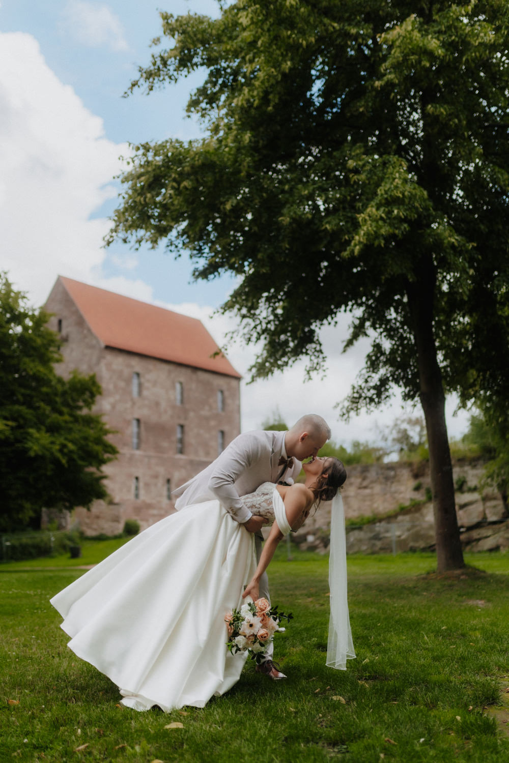 Bräutigam taucht Braut zum Kuss vor Burg Hardegsen