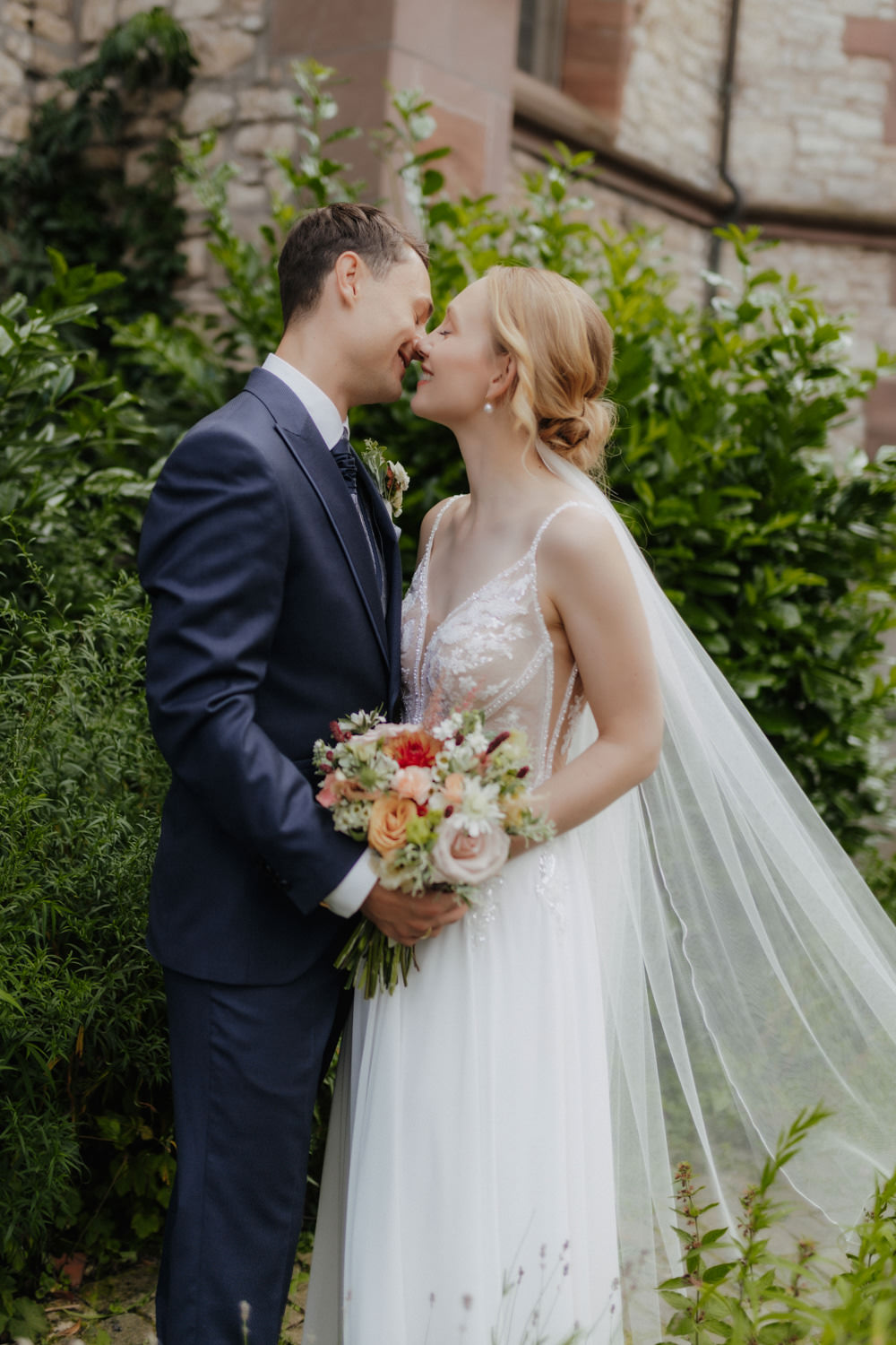 Brautpaar vor historischer Kirche in Göttingen, liebevoller Blick