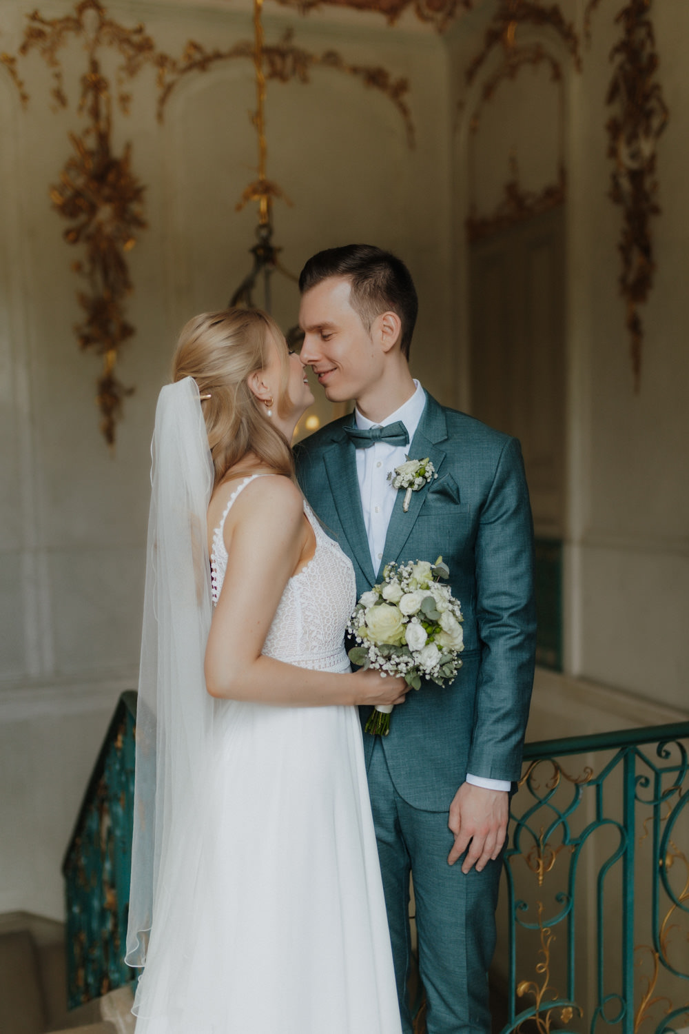 Brautpaar-lachend-beim-Fotoshooting Hochzeitspaar auf verzierten Treppen im Schloss Wilhelmsthal Kassel