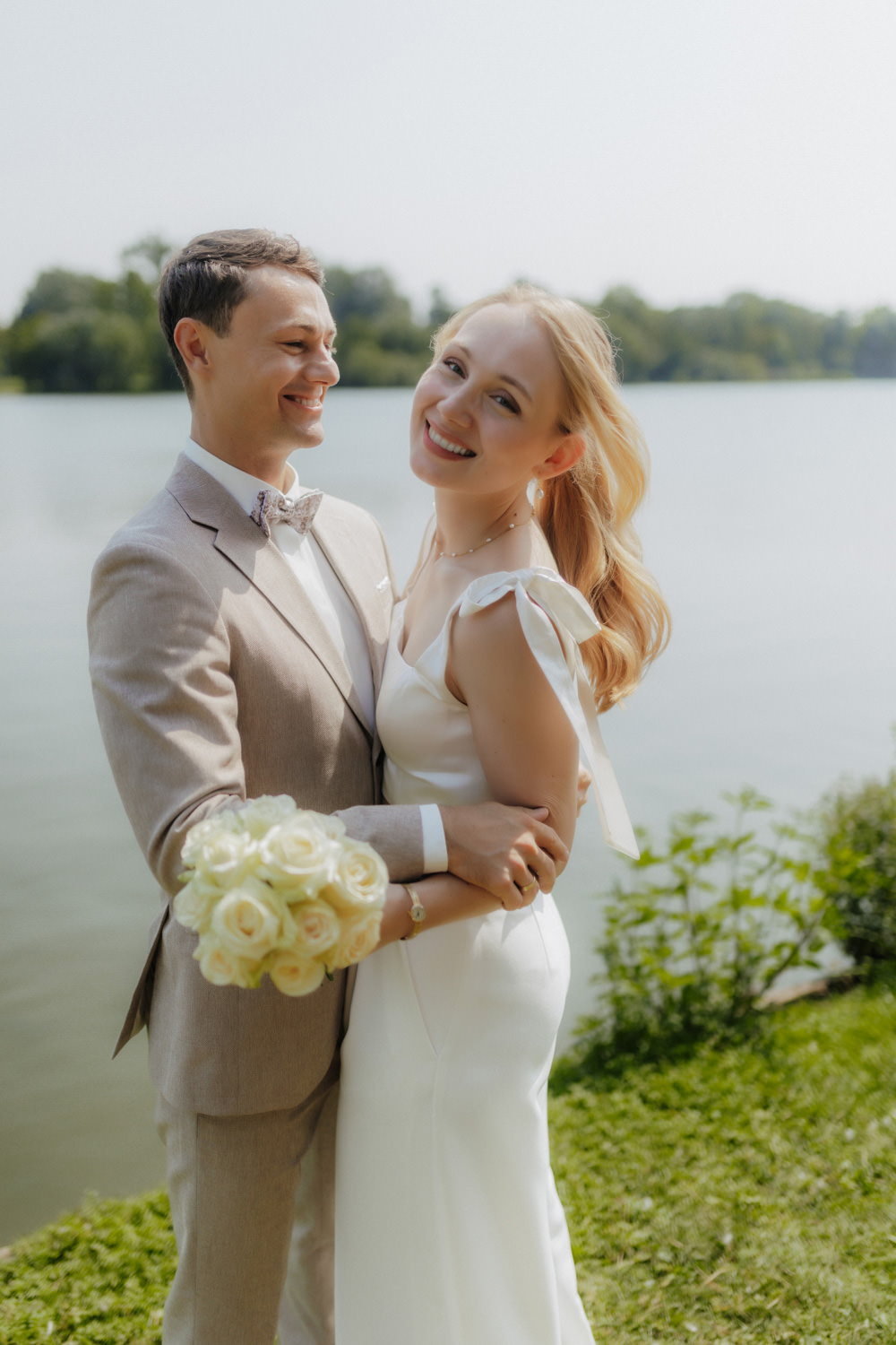 Lachendes Brautpaar am See – moderne Hochzeit bei Göttingen im Sommerlicht