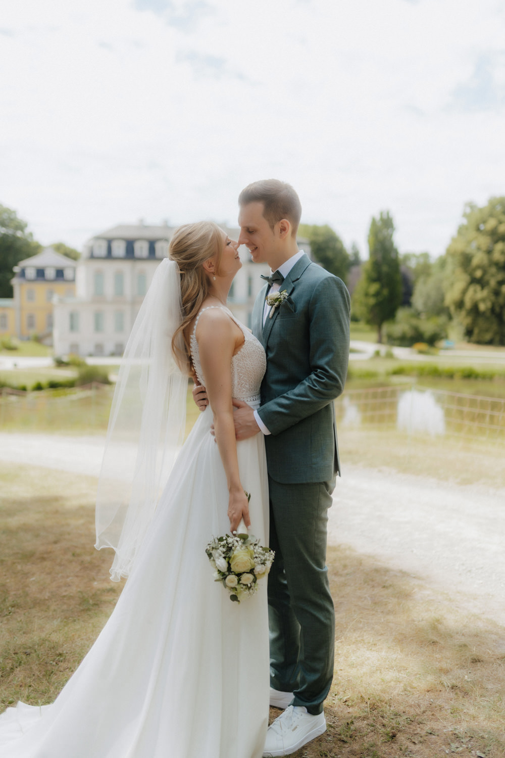 Brautpaar-lacht-sich-an Verliebter Blick des Brautpaars vor dem Schloss Wilhelmsthal bei Kassel