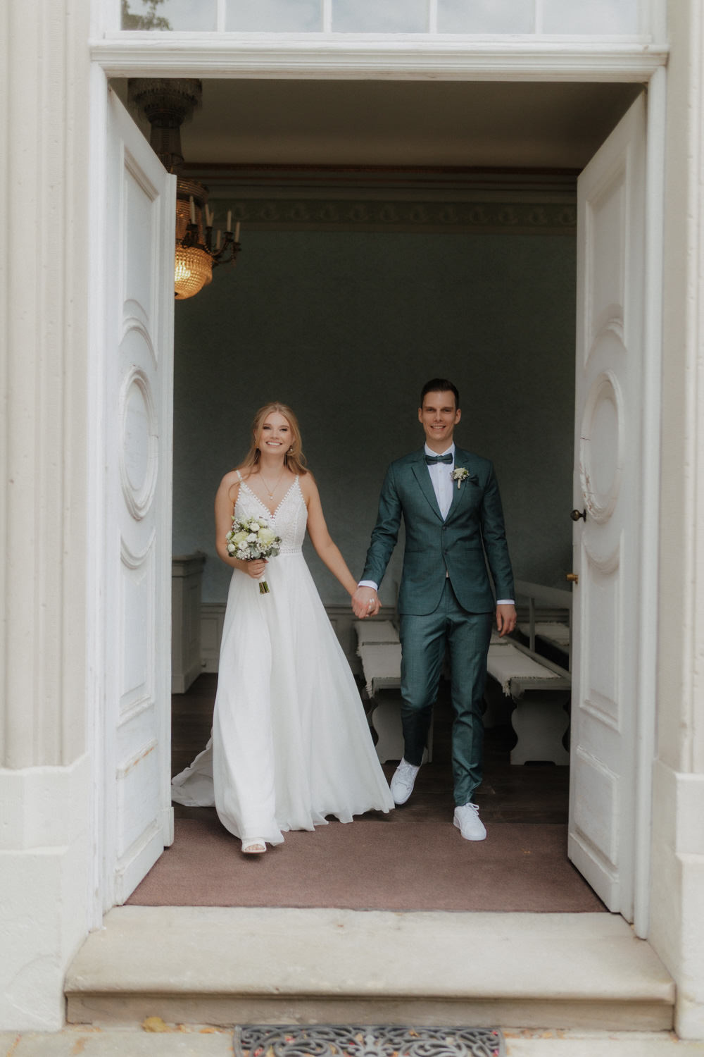 Brautpaar-verlaesst-standesamt Hochzeitspaar tritt aus dem Standesamt