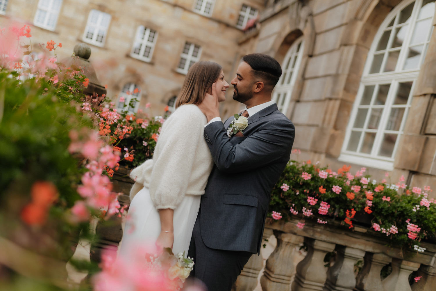 Hochzeitspaar vor Blumen und Fassade – Hochzeitsfotos Kassel