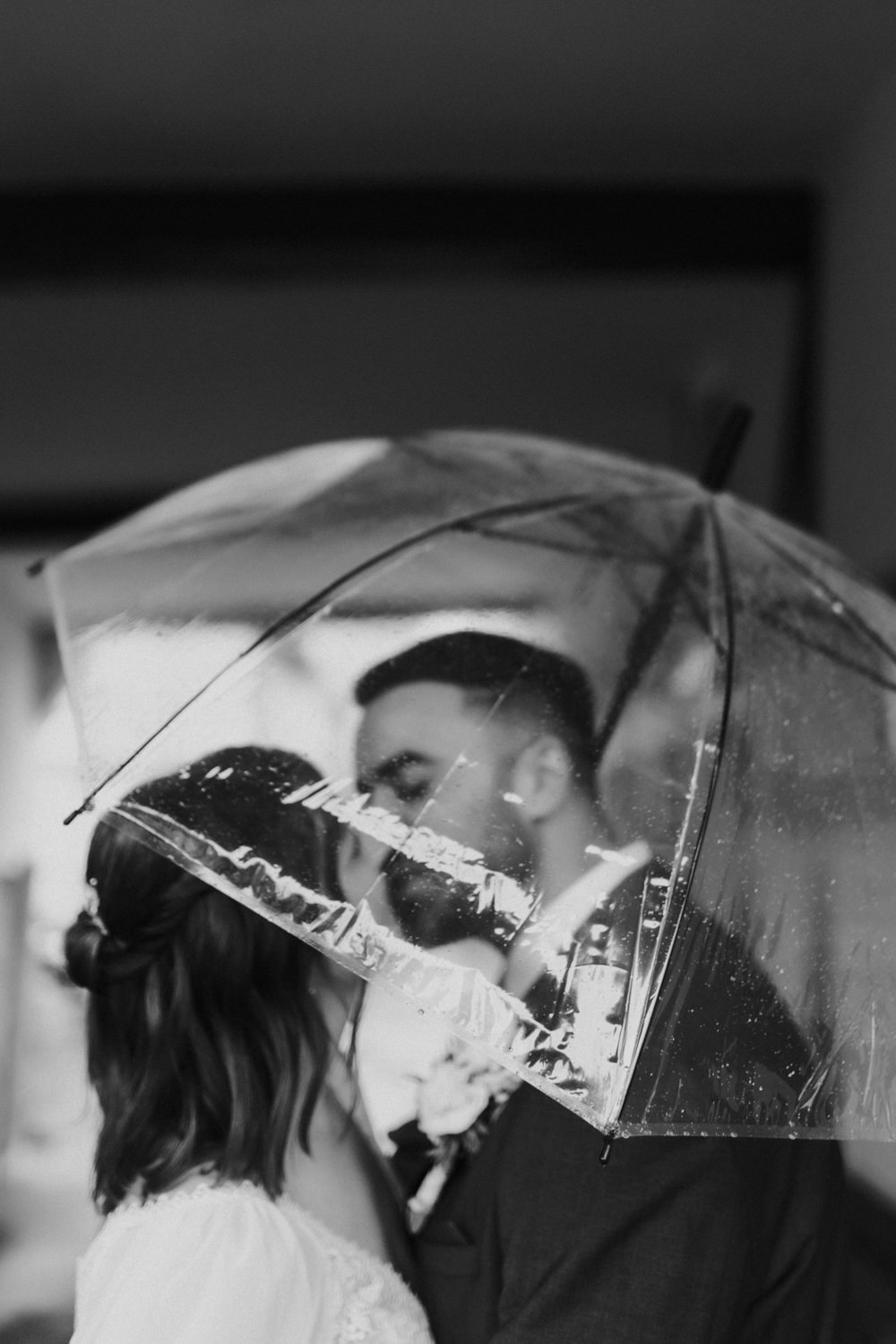 Regenhochzeit mit Kuss unterm Schirm – Hochzeitsfotograf Kassel