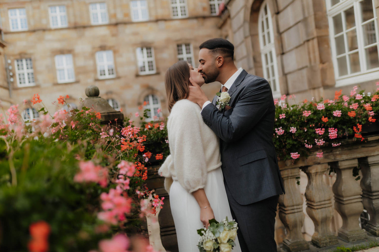 Brautpaar küsst sich im Hof des Standesamts Kassel