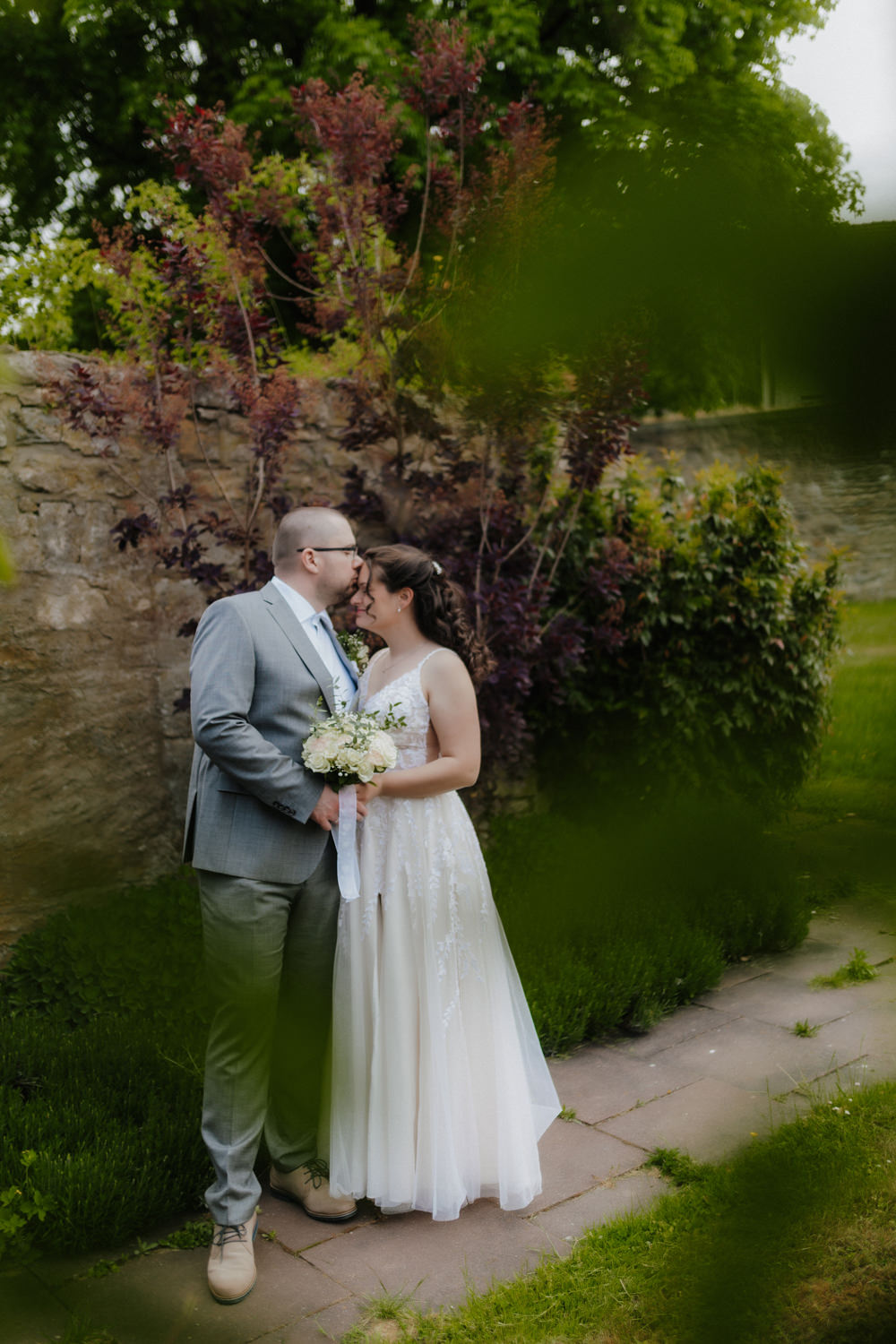 Brautpaar küsst sich im Garten von Schloss Gehrden – Hochzeitsfotografie Paderborn