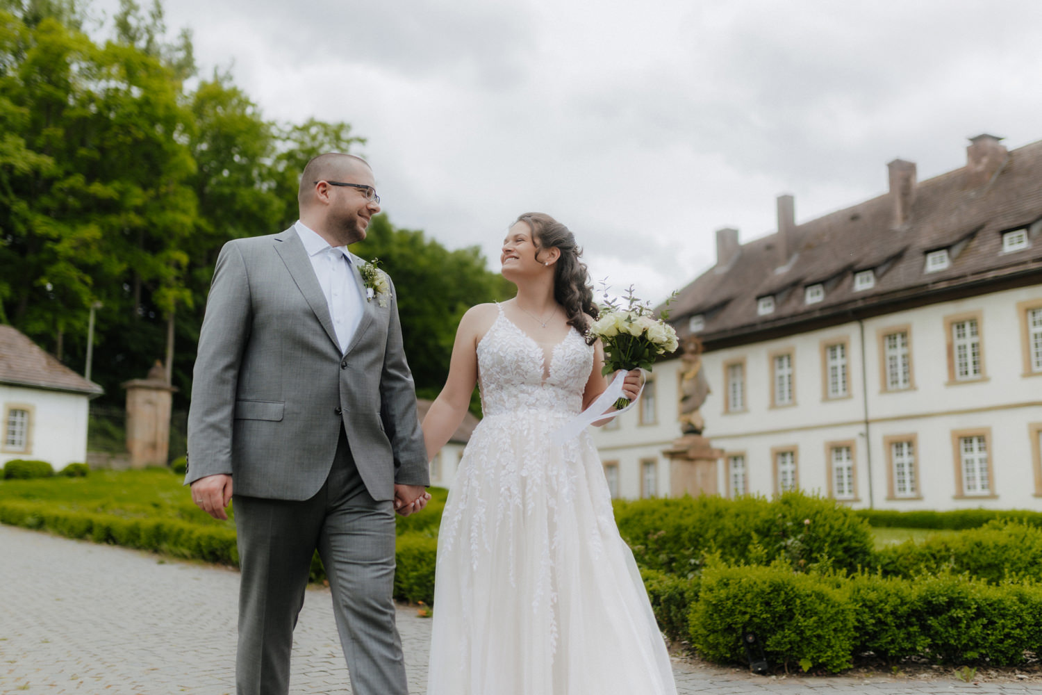 Brautpaar spaziert vor Schloss Gehrden – Hochzeitsfotograf Paderborn