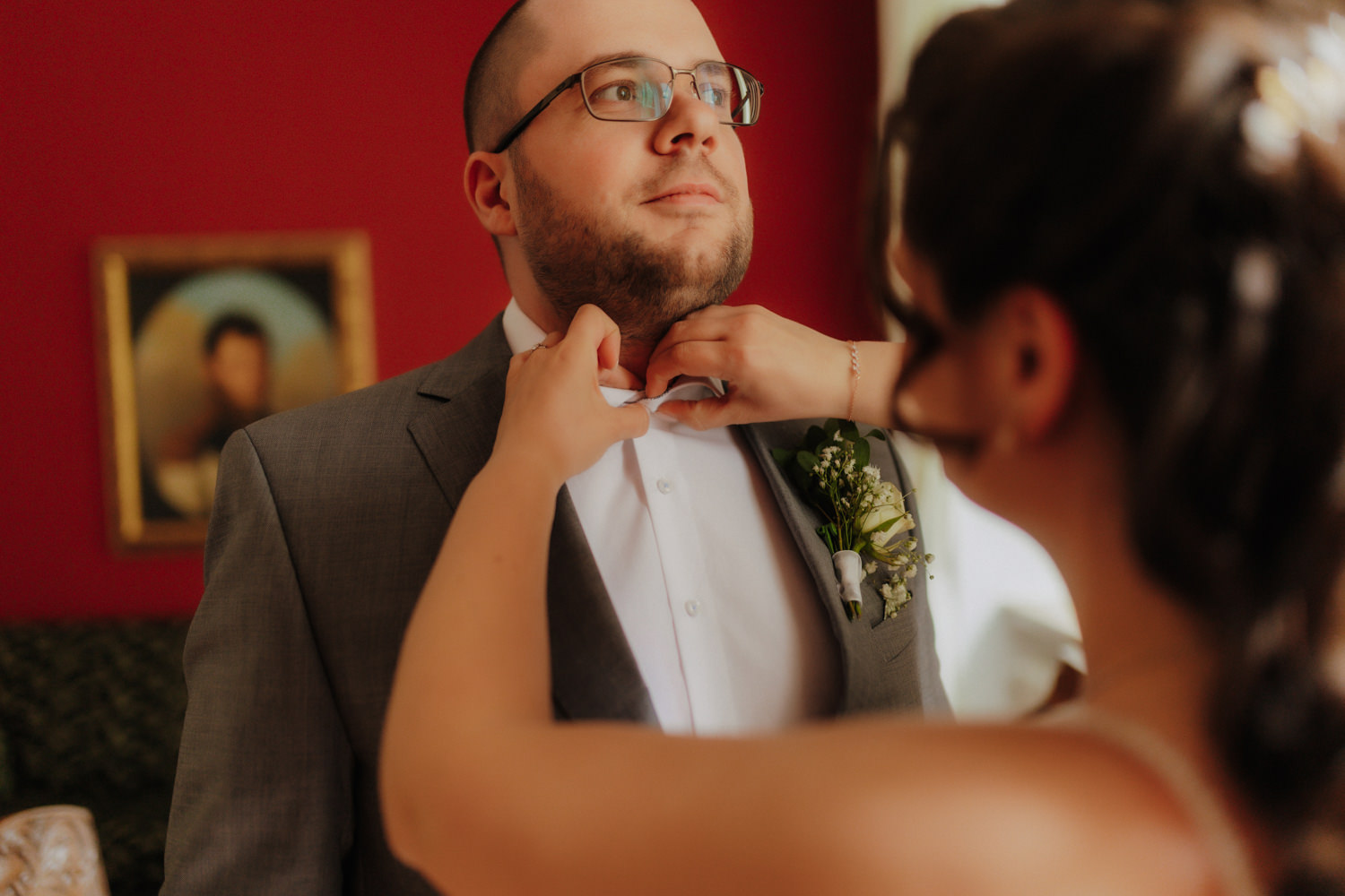 Braut hilft Bräutigam bei Fliege – emotionale Hochzeitsmomente Schloss Gehrden