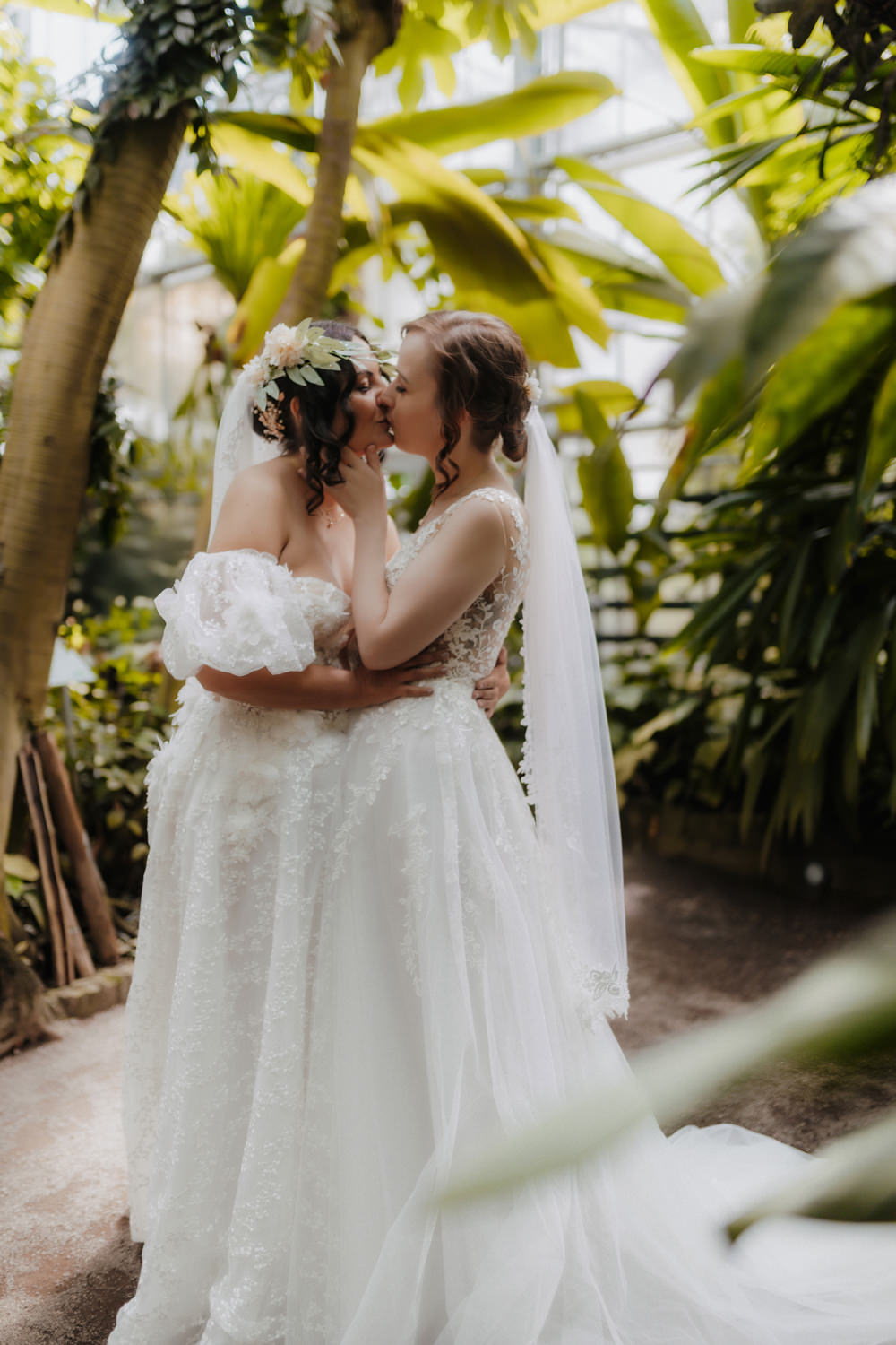 Hochzeitsfotografie LGBTQ Paar im Botanischen Garten Bonn beim Kuss zwischen Pflanzen