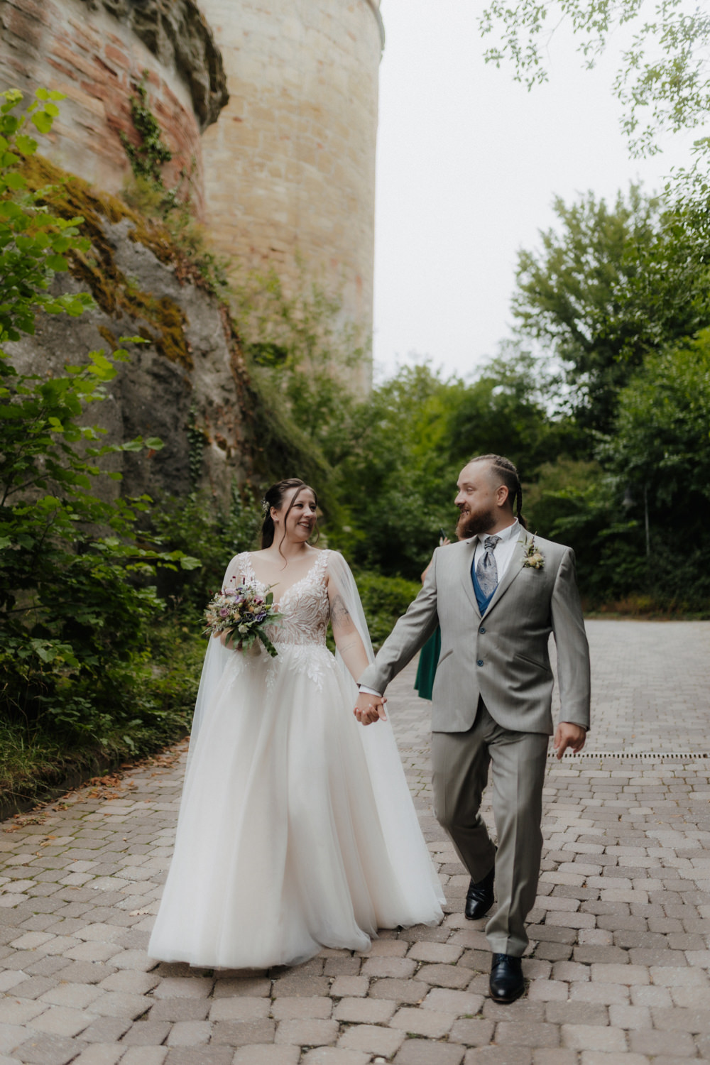 Brautpaar läuft Hand in Hand am Schloss Waldeck Hochzeitspaar