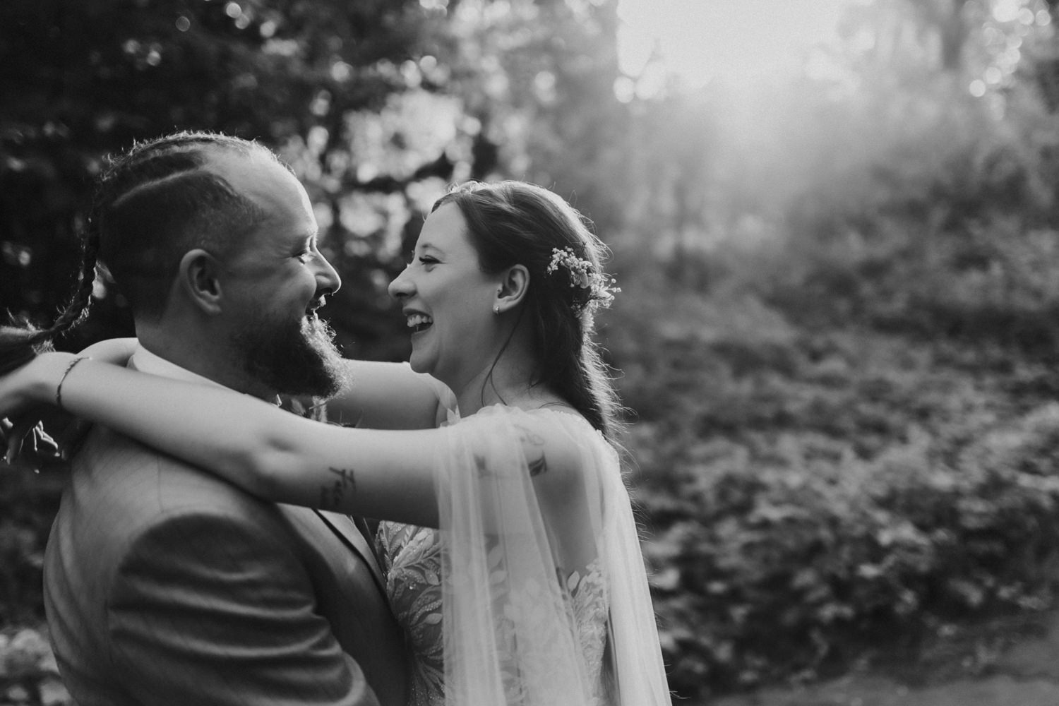 Lachendes Brautpaar im Sonnenlicht romantische Hochzeit im Wald