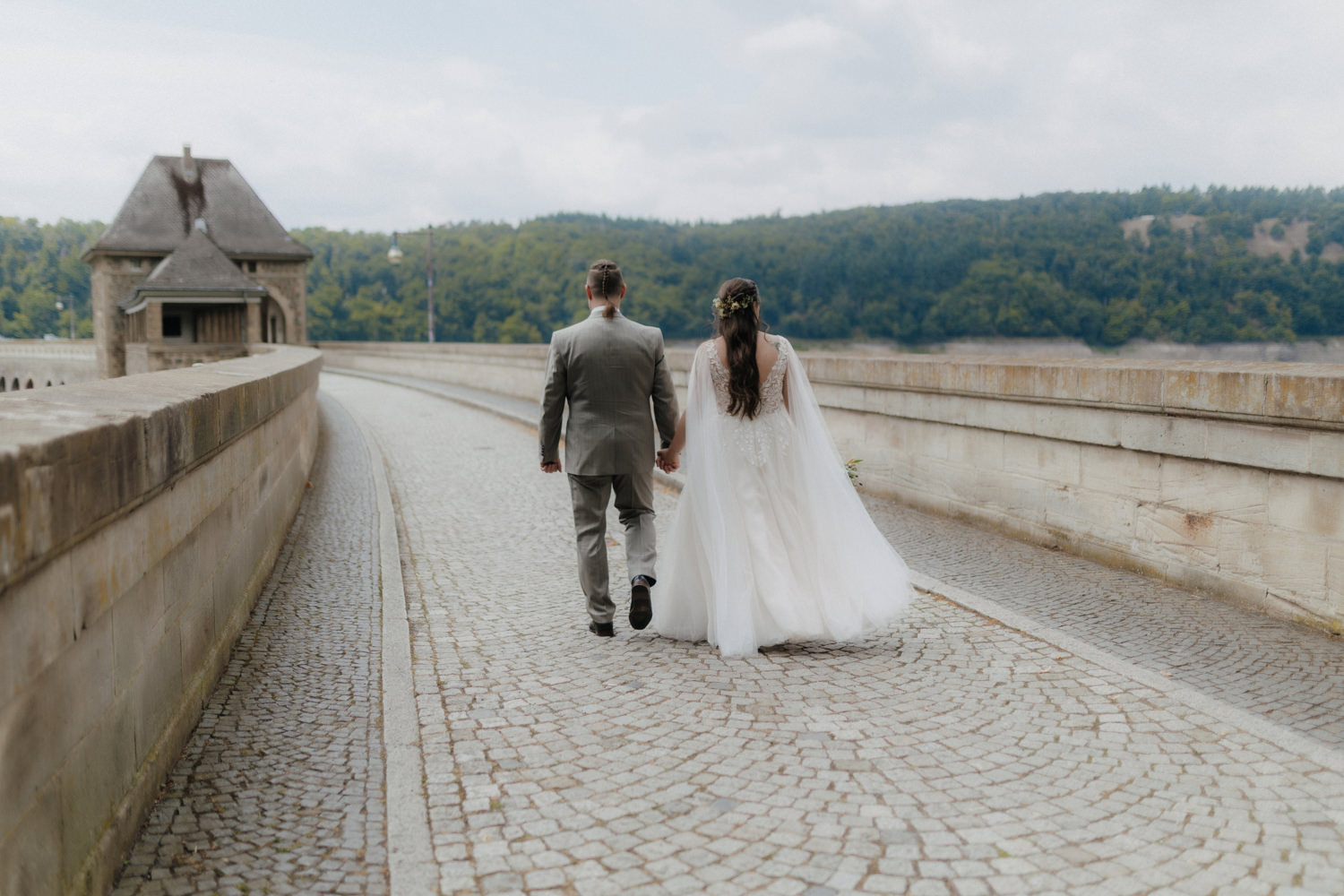 Brautpaar läuft über Staumauer Edersee Hochzeit Schloss Waldeck