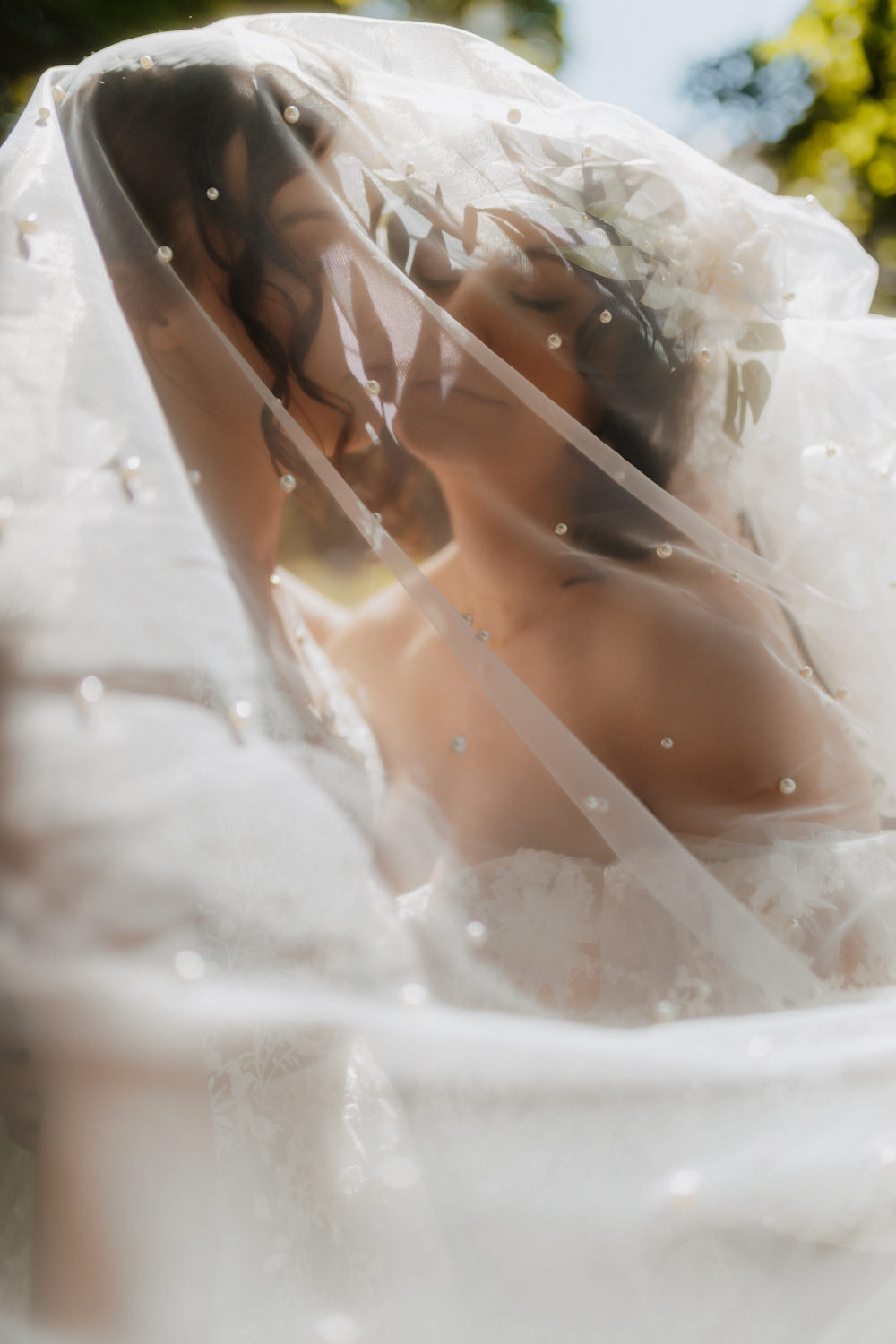 Künstlerische Hochzeitsfotografie Bonn, Braut unter Schleier im Gegenlicht