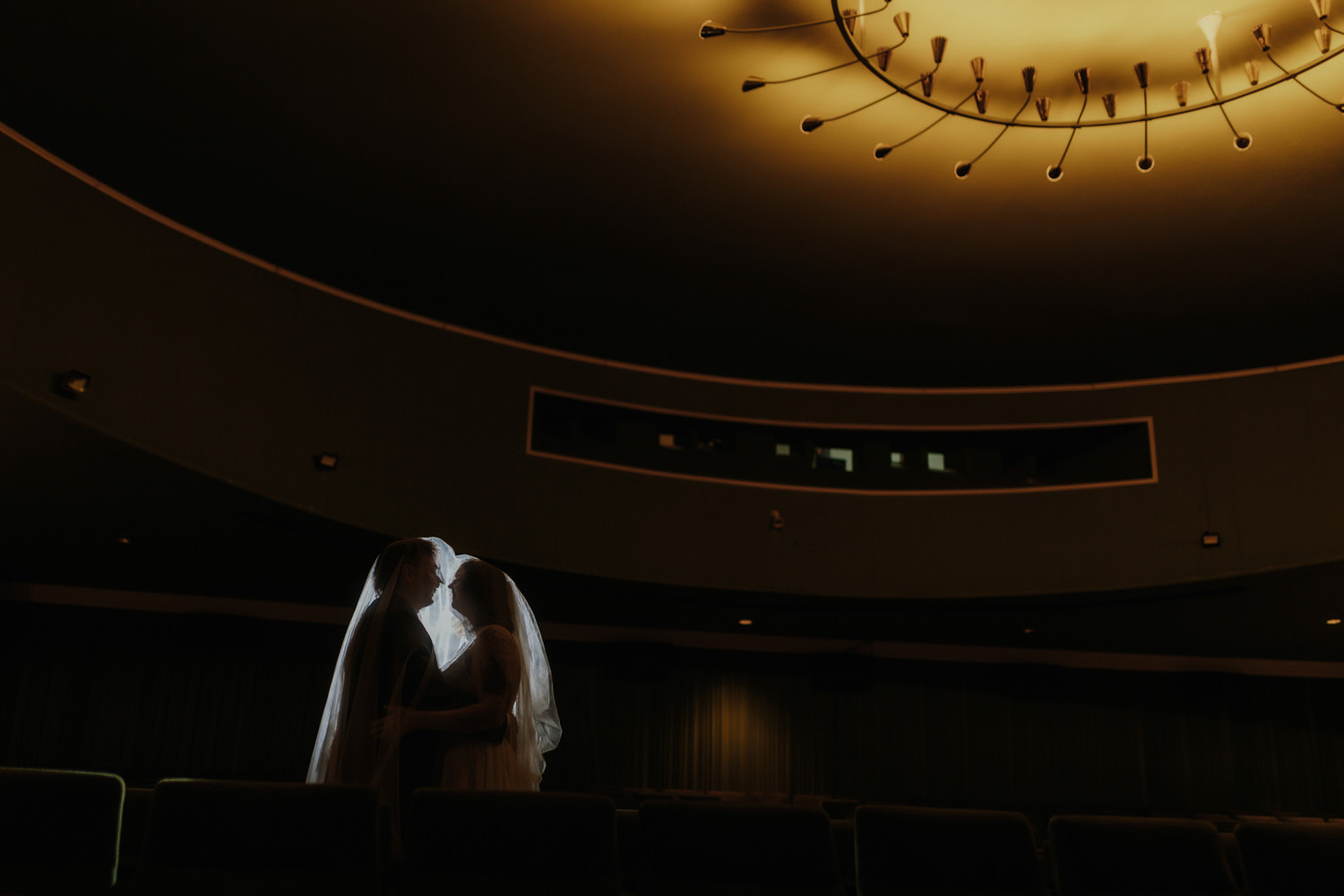 Warmes Licht im Kino – Brautpaar Kuss bei moderner Hochzeitsreportage