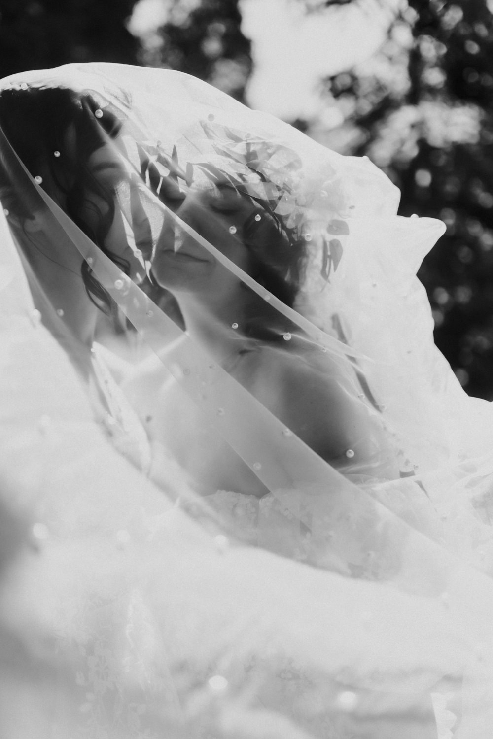 Künstlerische Hochzeitsfotografie Bonn, Braut unter Schleier im Gegenlicht in schwarzweiss.