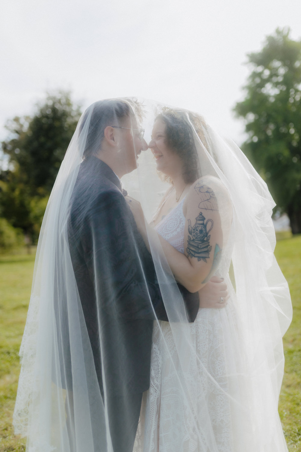 Brautpaar unter Schleier im Park – romantische Hochzeitsfotos Kassel