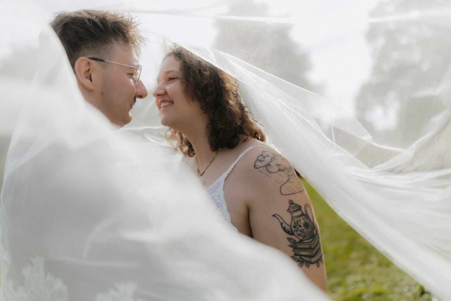 Intimes Paarportrait unter Schleier – natürliche Hochzeitsfotografie draußen