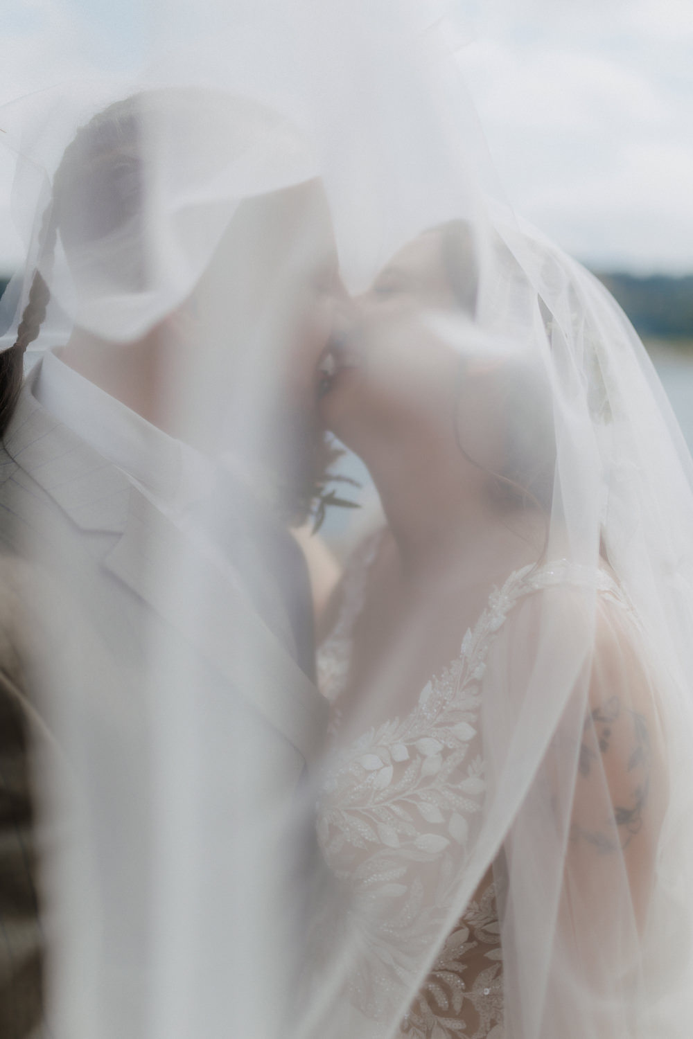 Romantischer Kuss unter Schleier am Edersee Hochzeitspaar