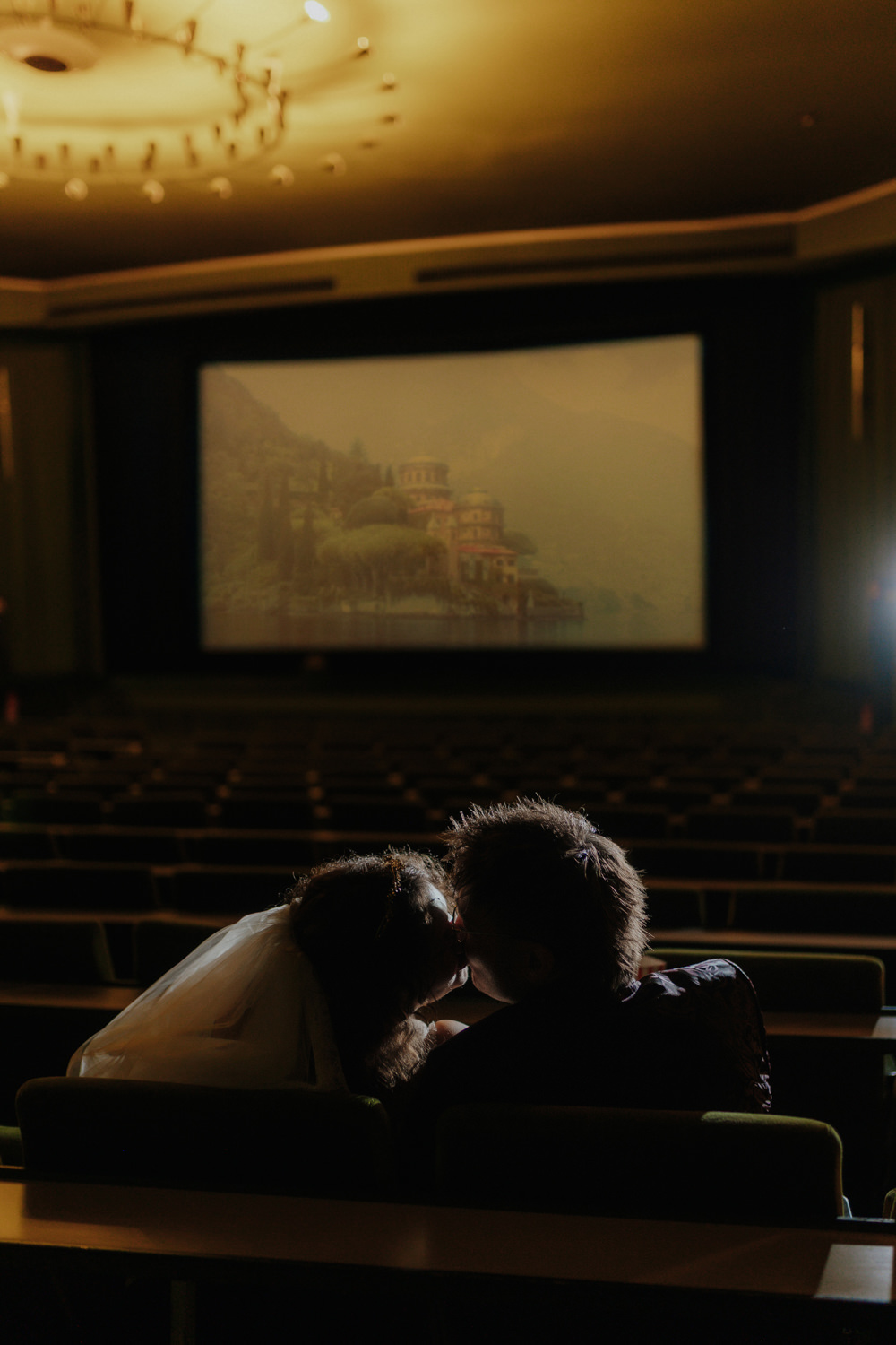 Kuss im Kinosaal vor Leinwand – emotionale Hochzeitsfotografie Kassel