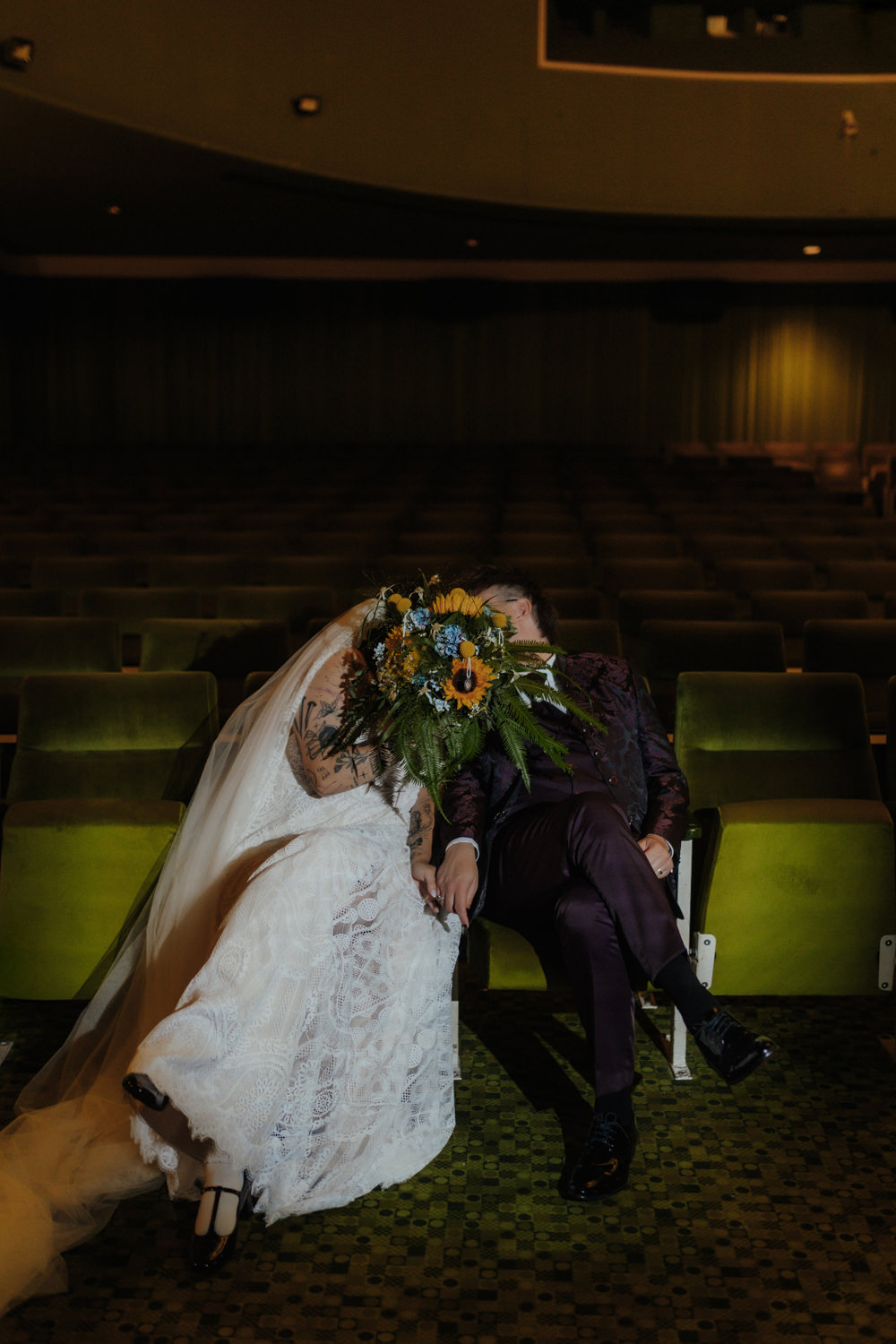 Brautpaar mit Sonnenblumenstrauß im Kino – moderne Hochzeitsreportage