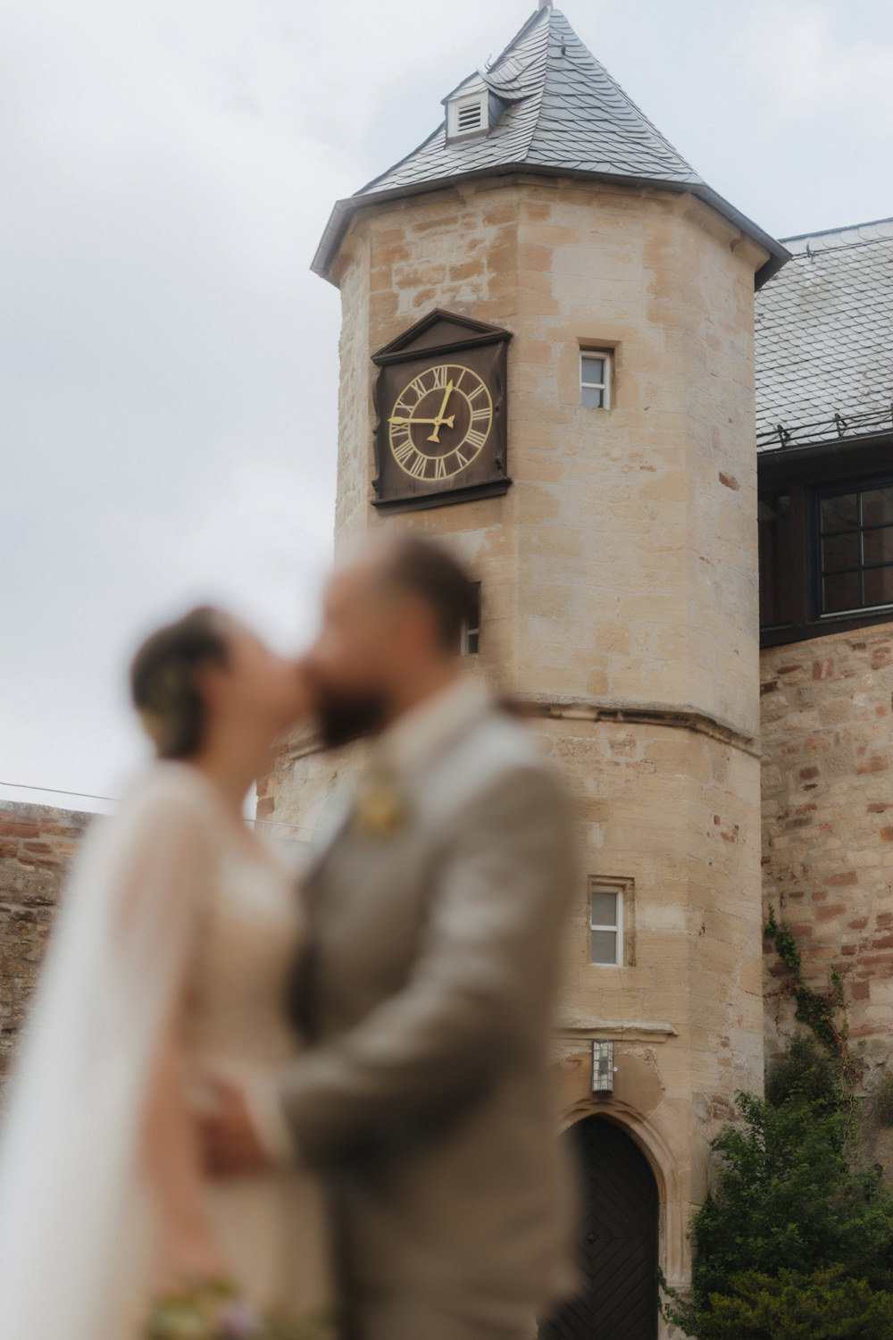 Unscharfes Brautpaar vor Schlossturm kreative Hochzeitsfotografie