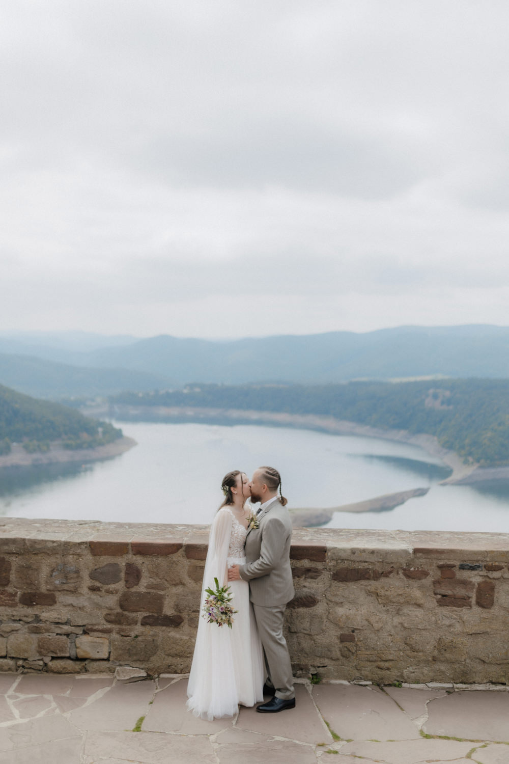Hochzeitspaar küsst sich mit Blick auf Edersee Panorama Waldeck