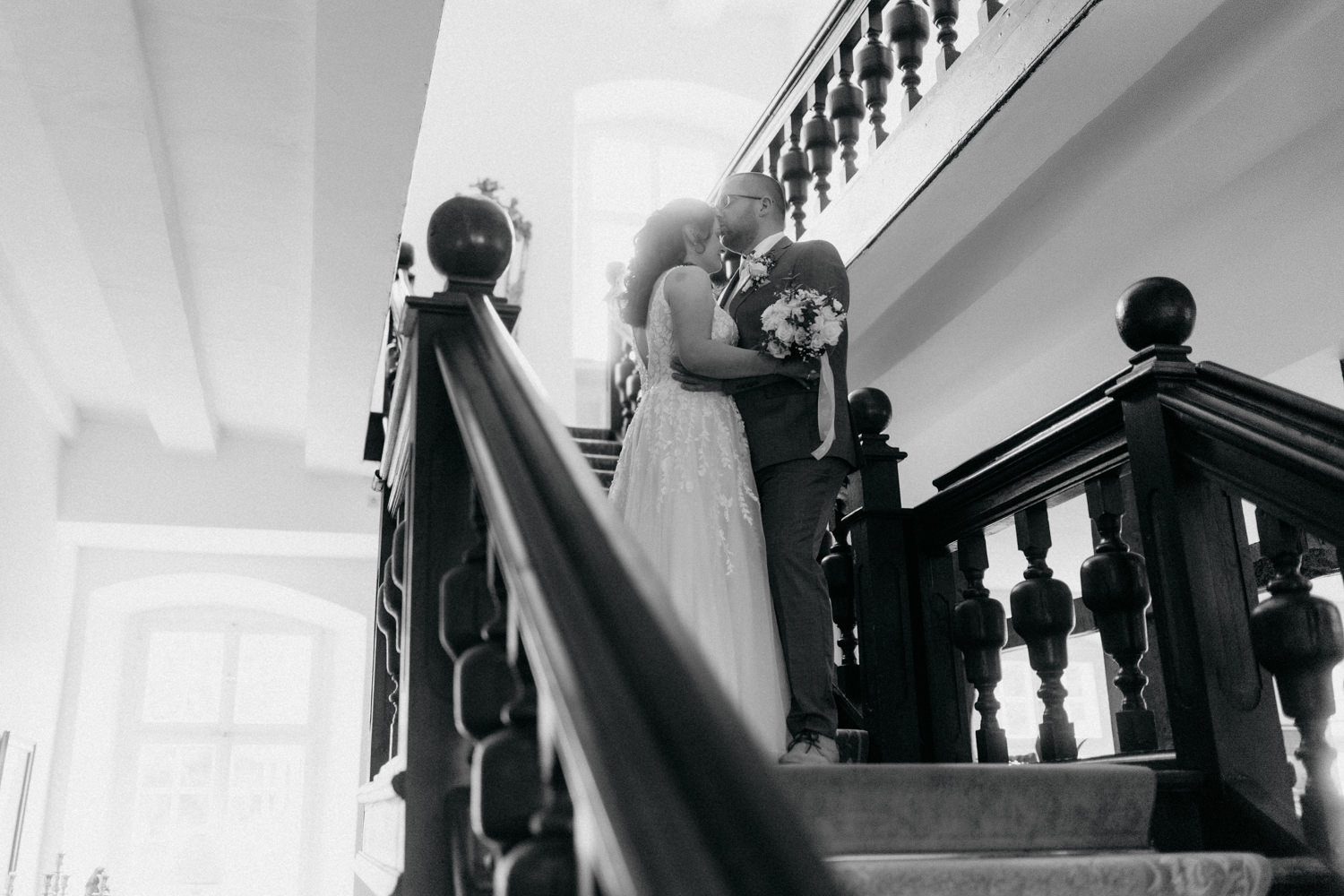 Brautpaar auf Treppe im Schloss – romantische Hochzeitsfotografie Paderborn