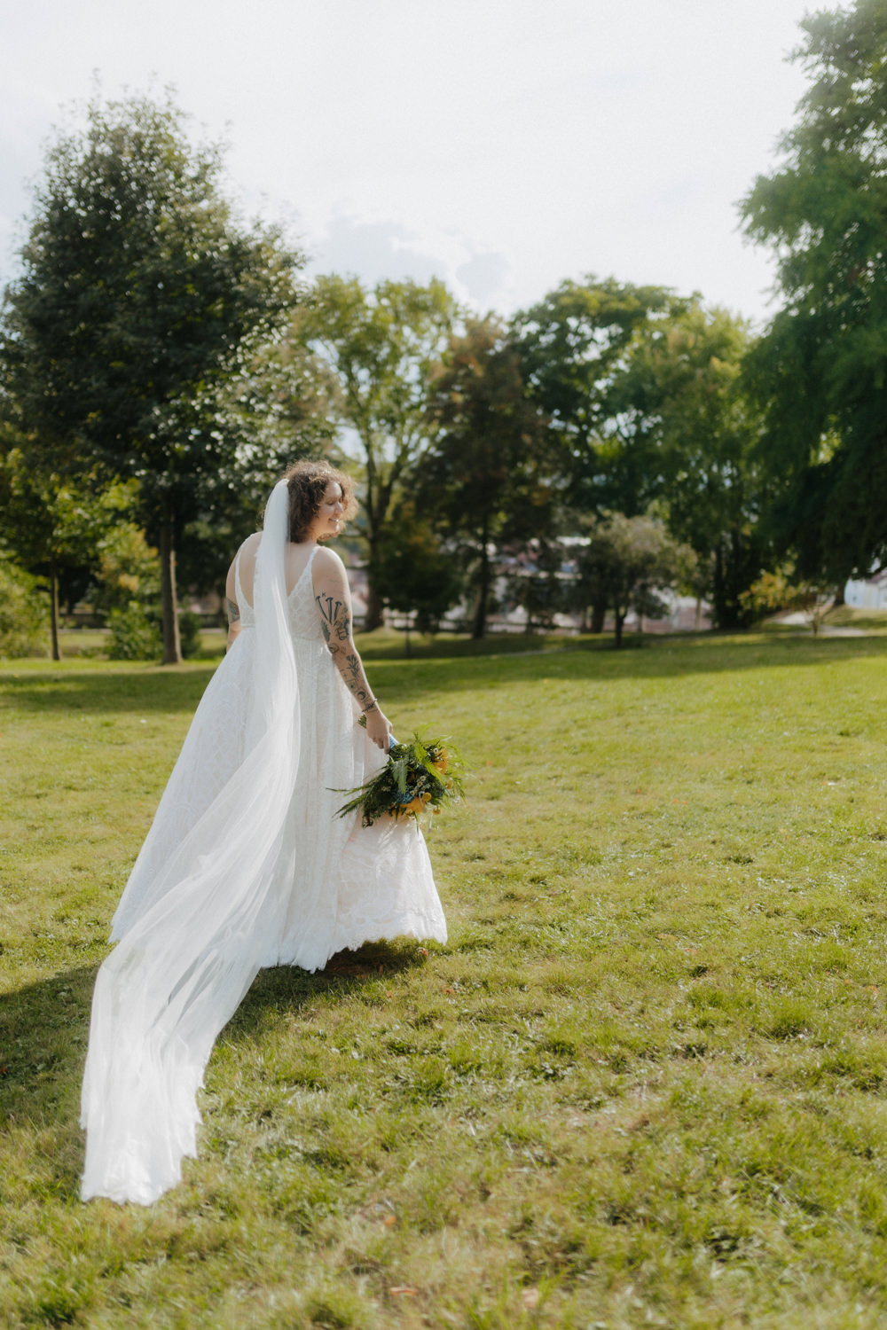 Braut läuft mit Schleier über Wiese – romantische Outdoor Hochzeit Kassel