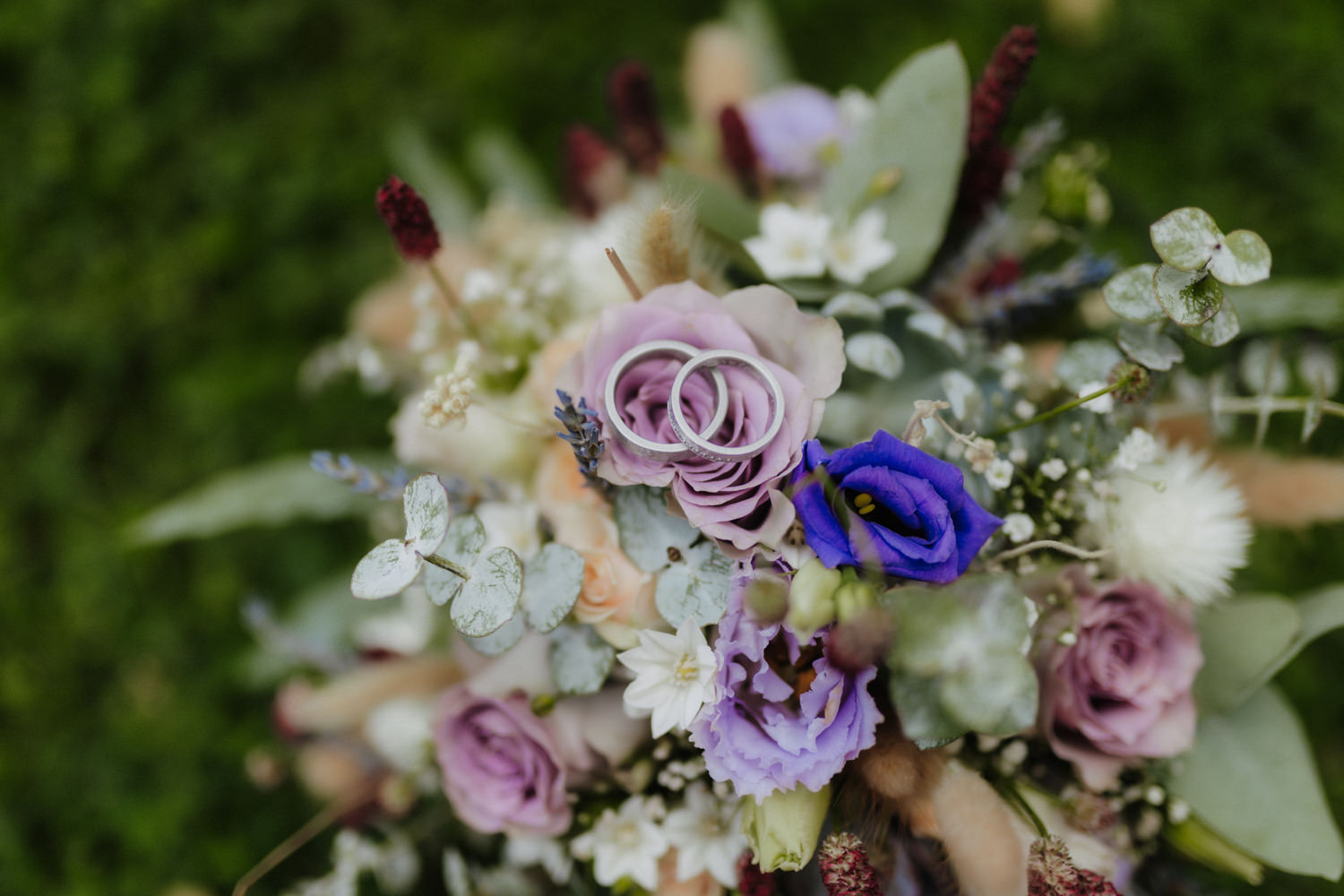 Eheringe auf Brautstrauß Detail Hochzeitsfotografie