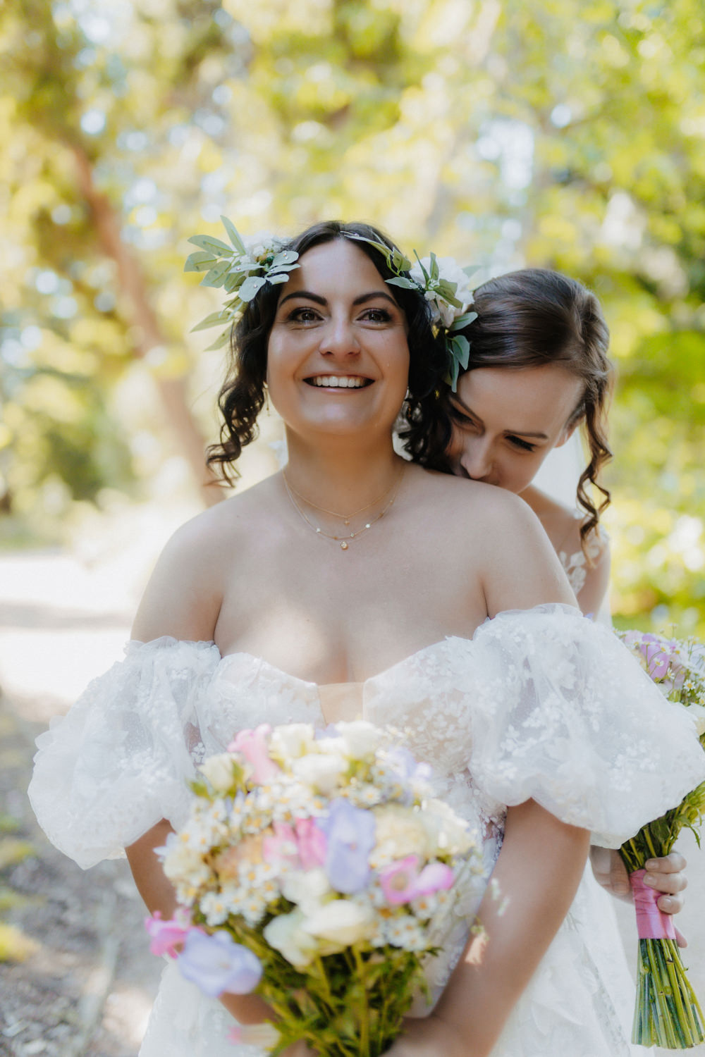 Glückliches lesbisches Brautpaar im Botanischen Garten Bonn mit Blumenstrauß