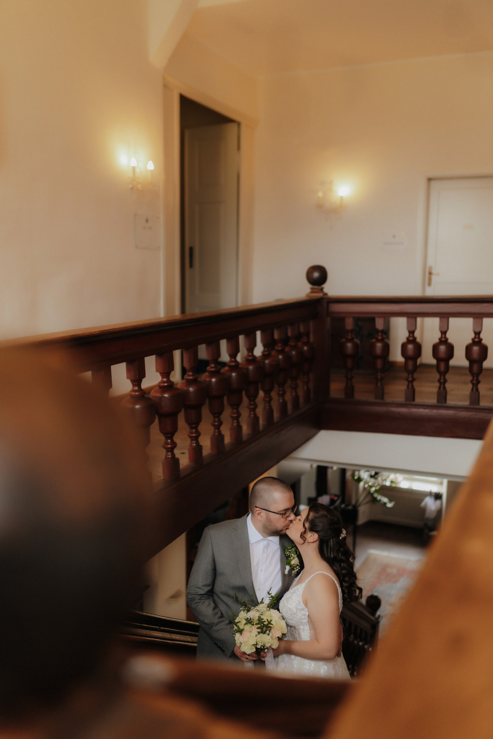 Brautpaar küsst sich auf Treppe – Hochzeitsfotografie Schloss Gehrden